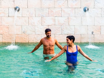 a man and woman in a pool with water jets