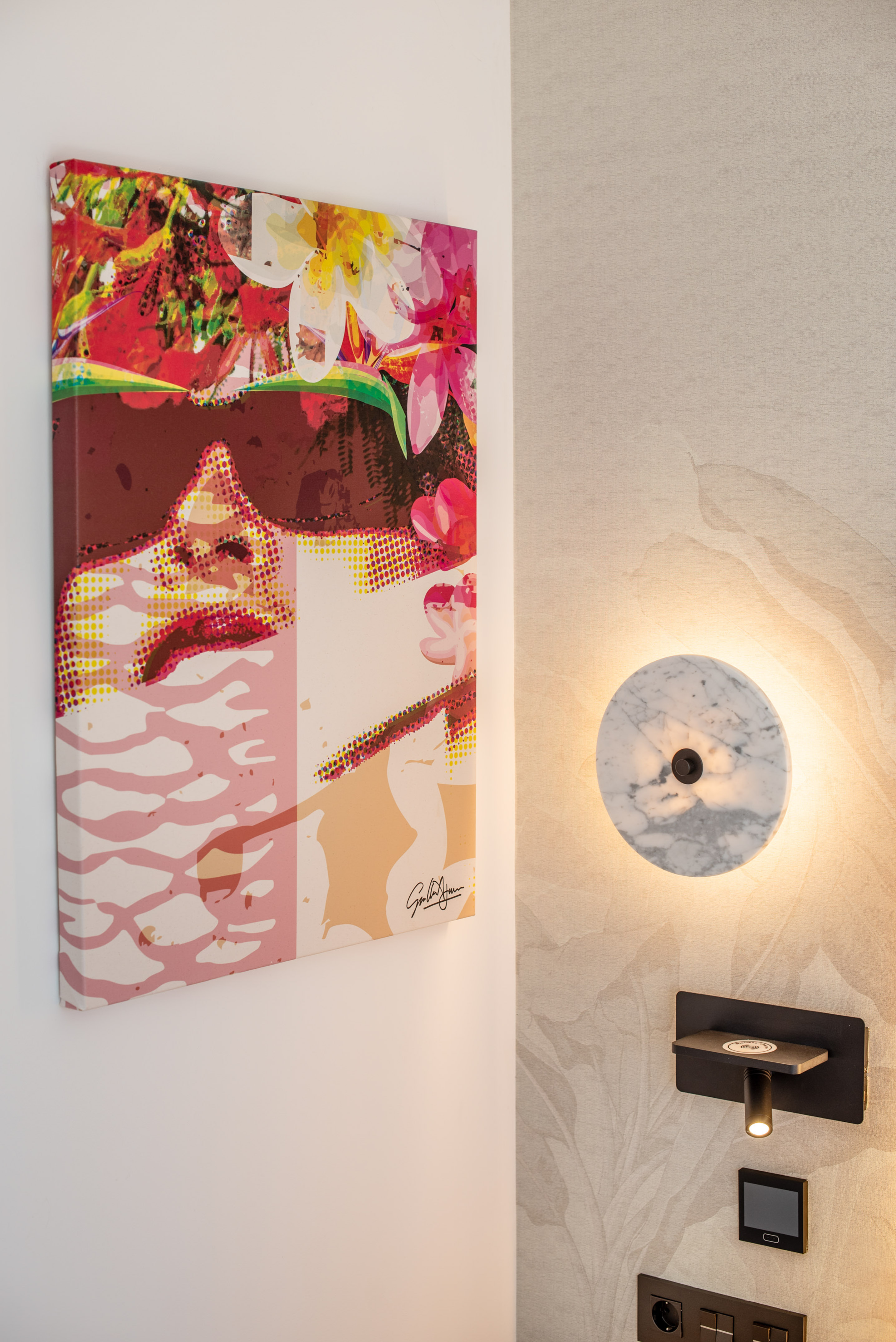 Colorful pop art canvas, marble wall lamp, and modern bedside lighting.
