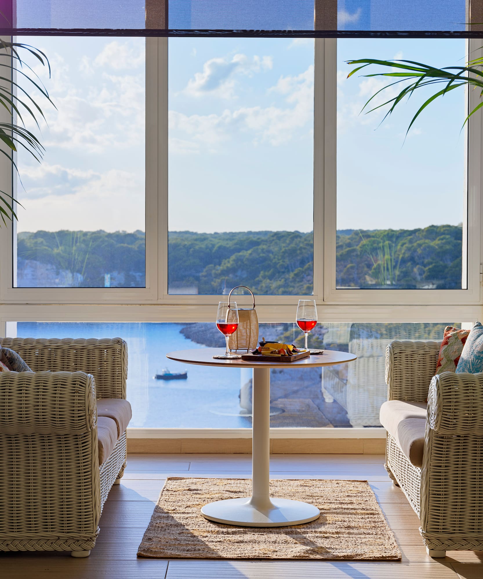 a room with a table and chairs and a view of the ocean