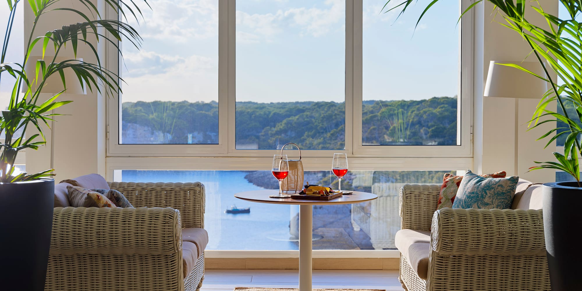 a room with a table and chairs and a view of the ocean