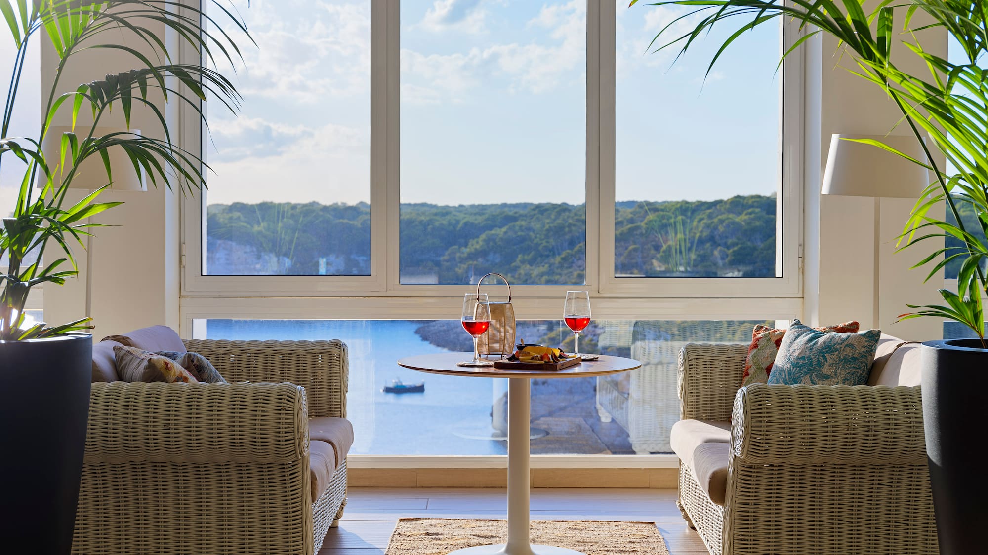 a room with a table and chairs and a view of the ocean