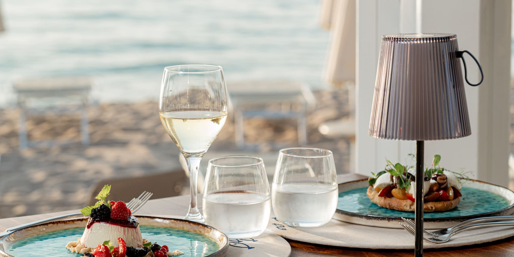a table with plates of food and glasses of wine