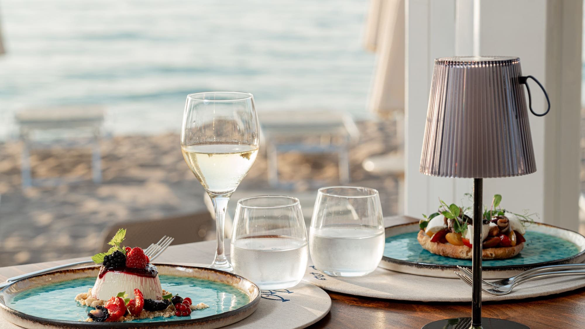 a table with plates of food and glasses of wine