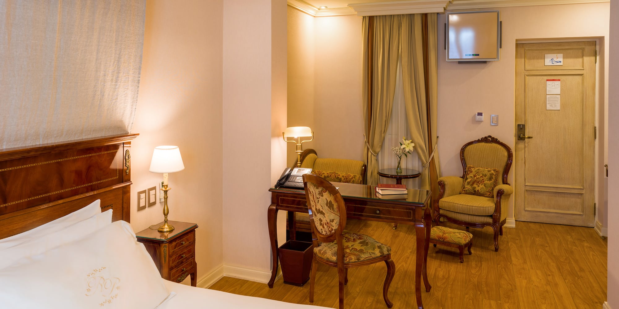 a room with a bed and chairs