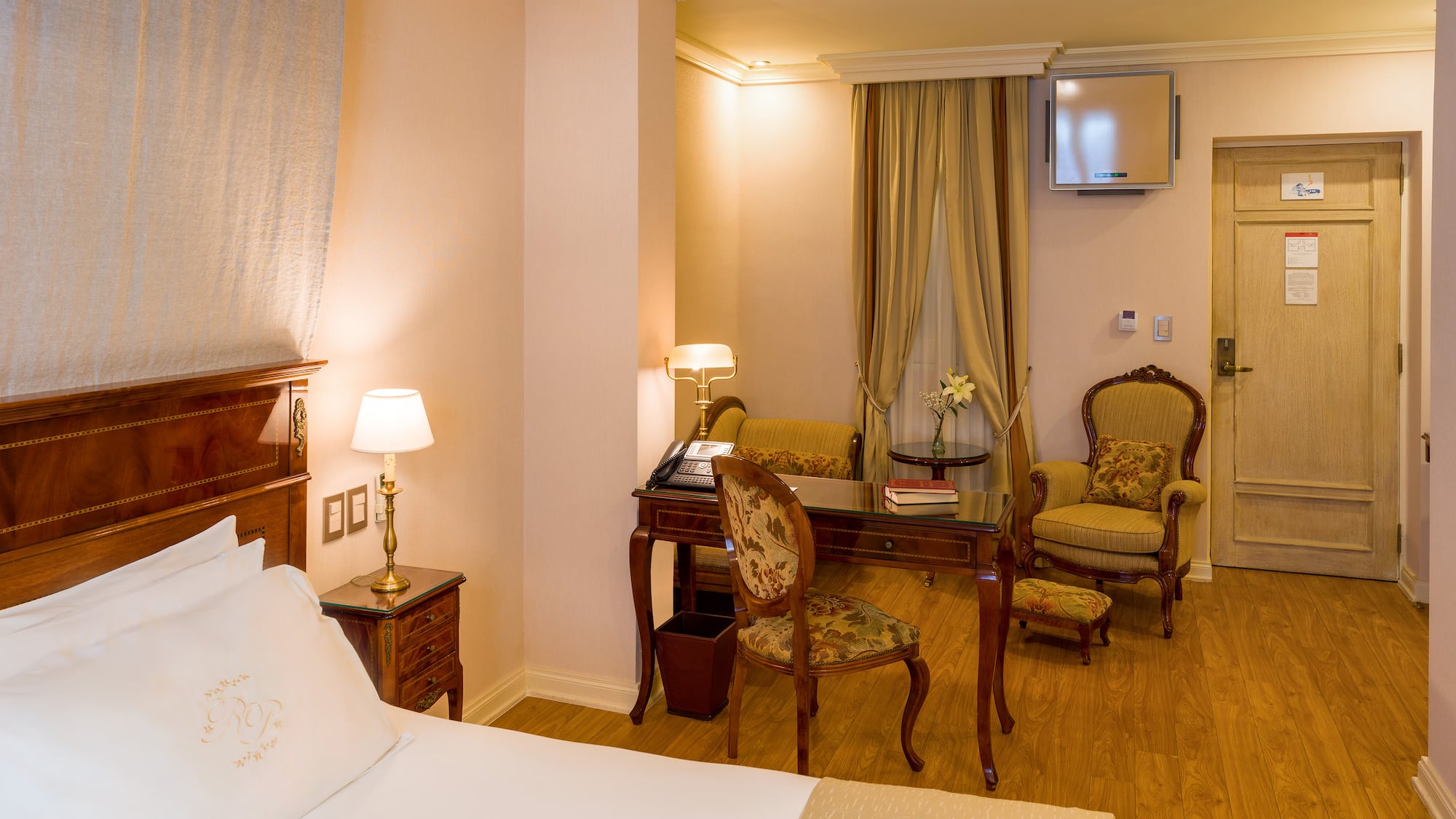 a room with a bed and chairs