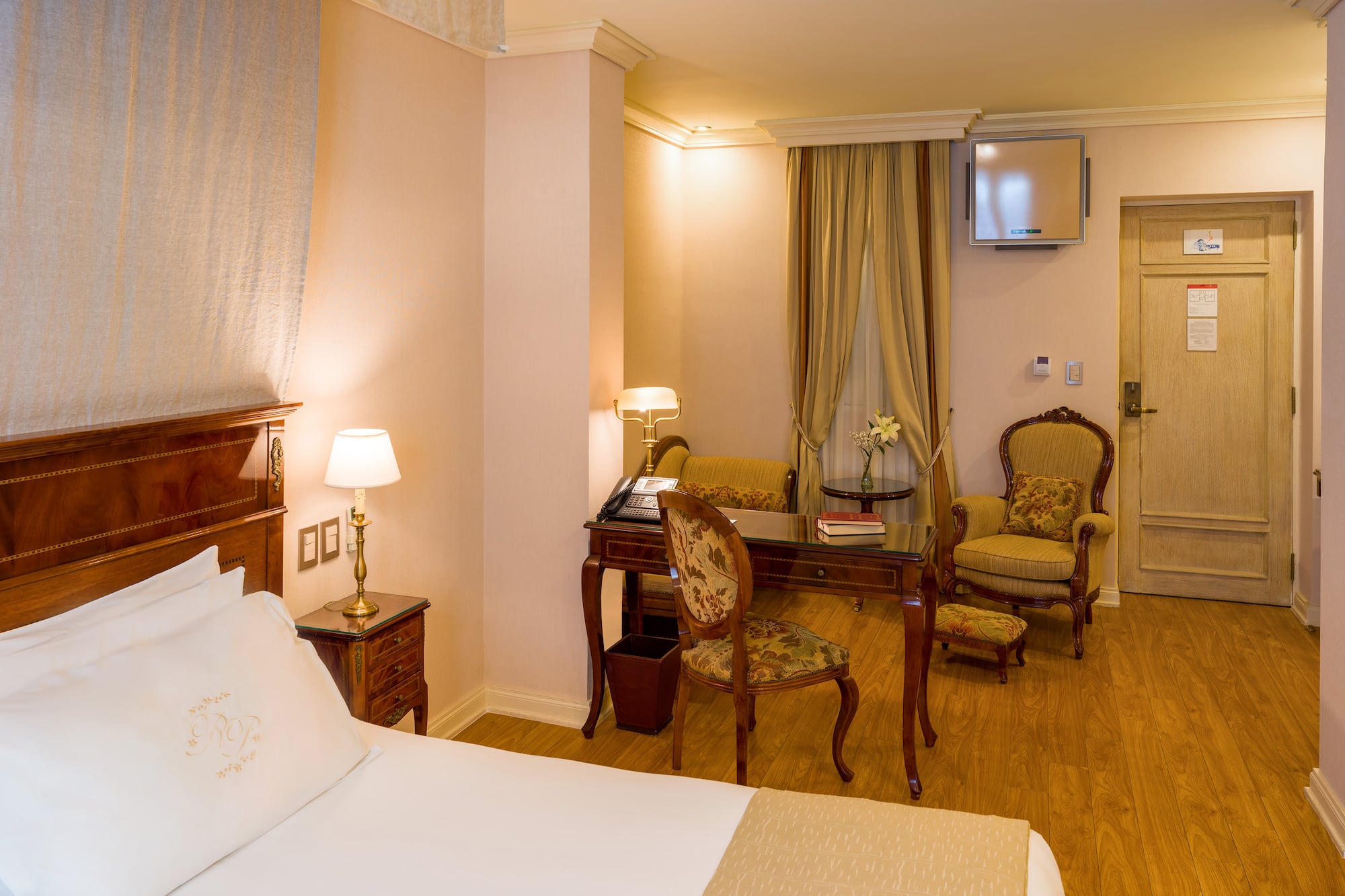 a room with a bed and chairs