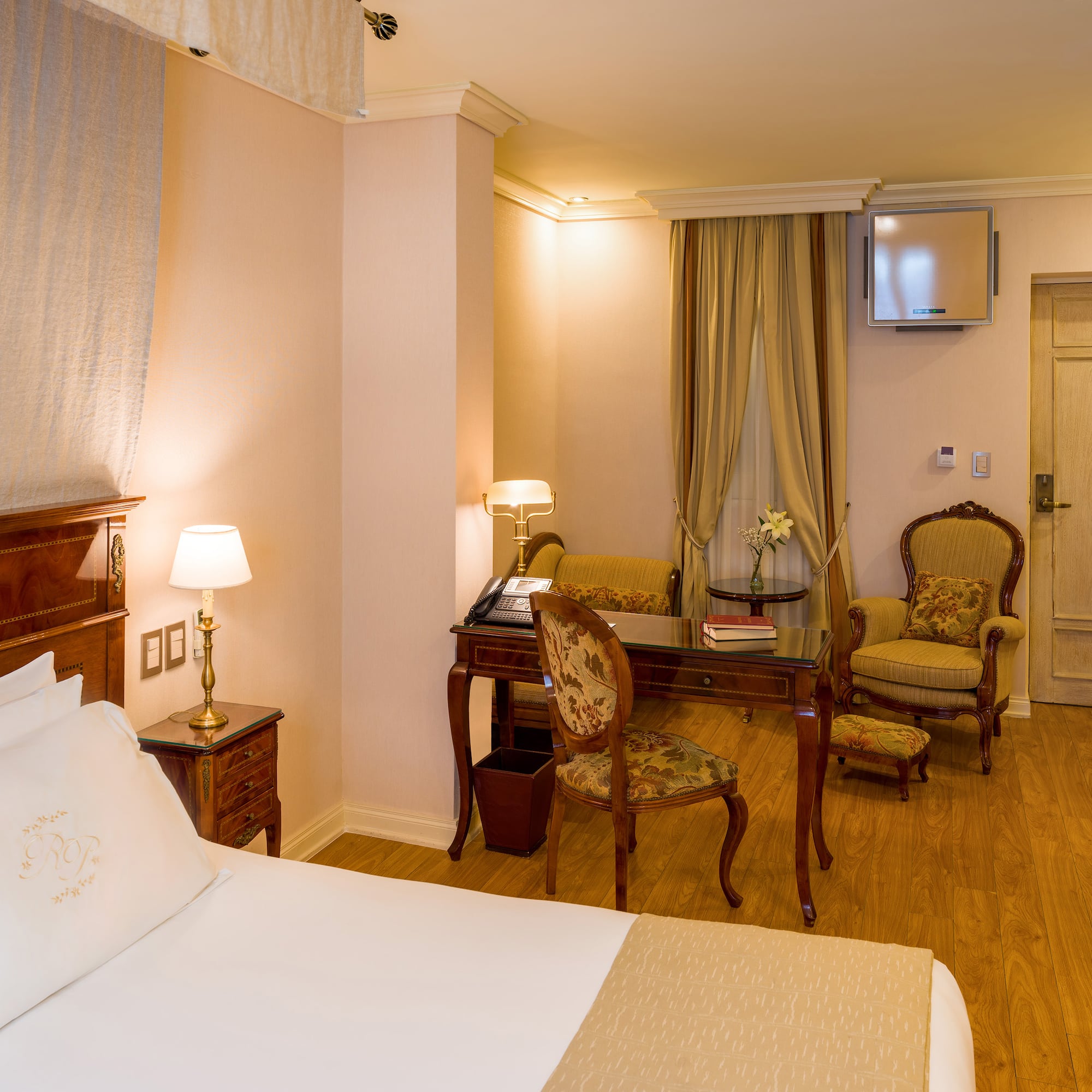 a room with a bed and chairs