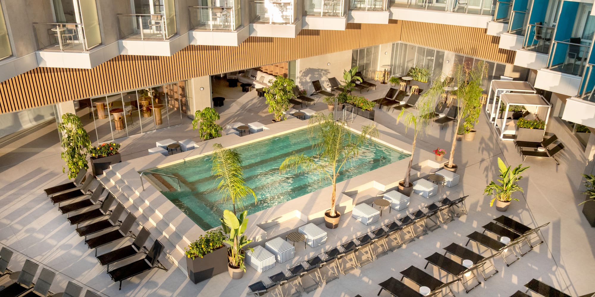 a pool with chairs and lounge chairs in a hotel