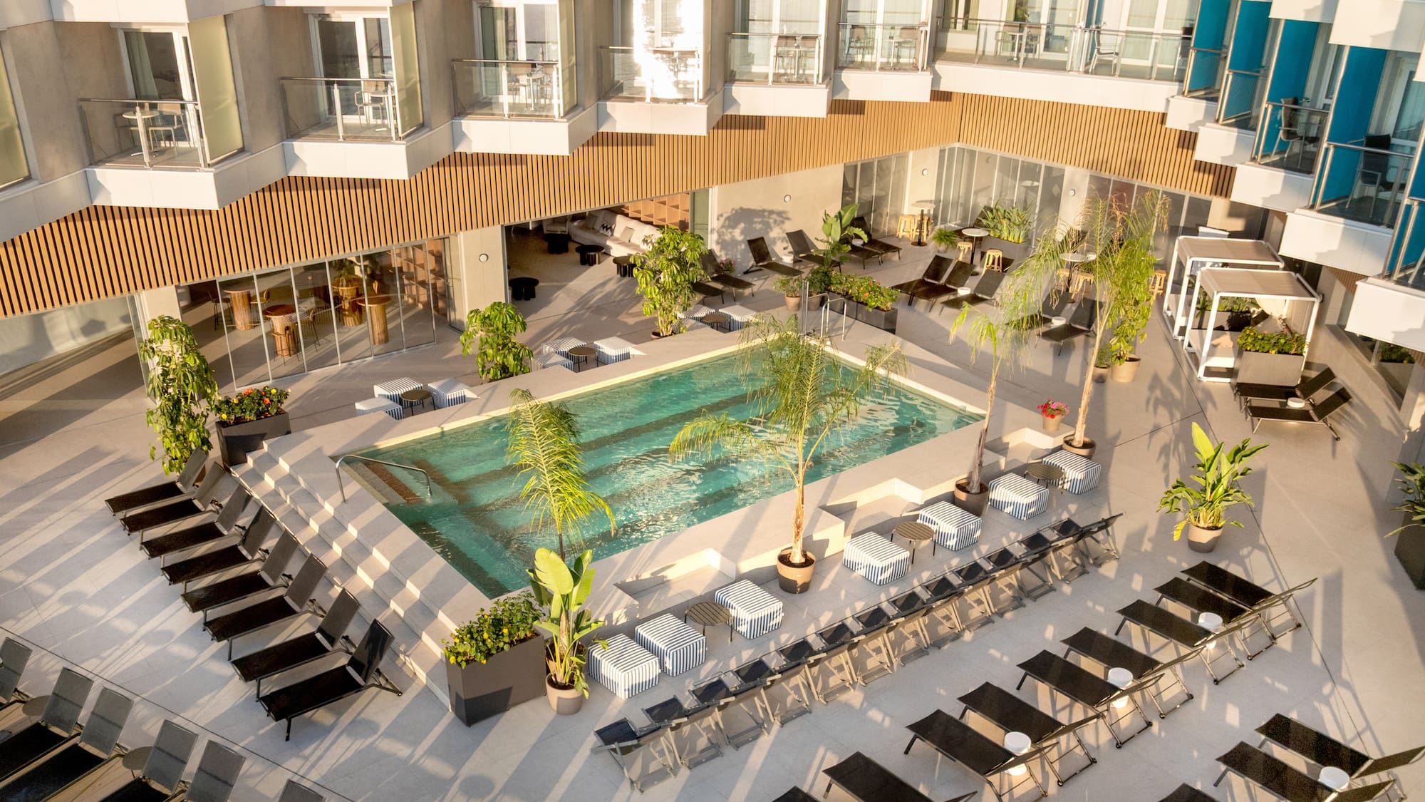 a pool with chairs and lounge chairs in a hotel