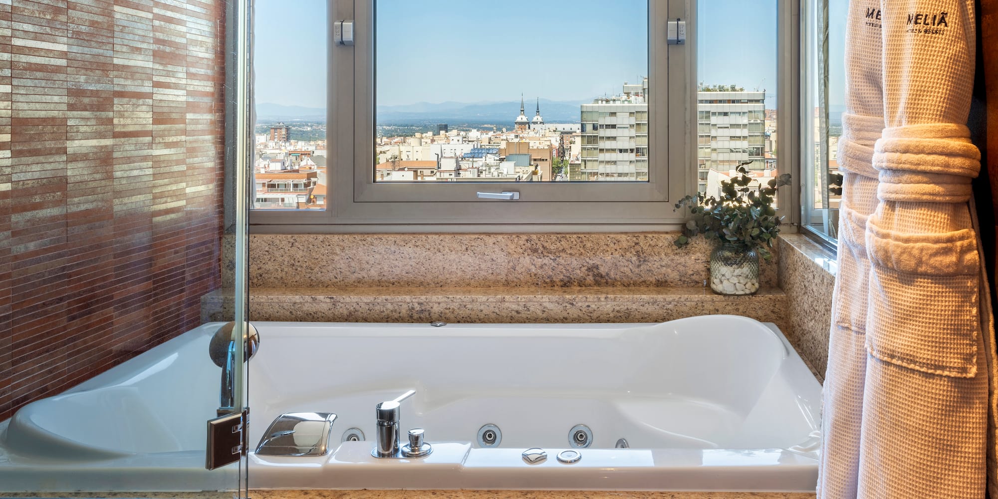 a bathtub with a window and a view of a city