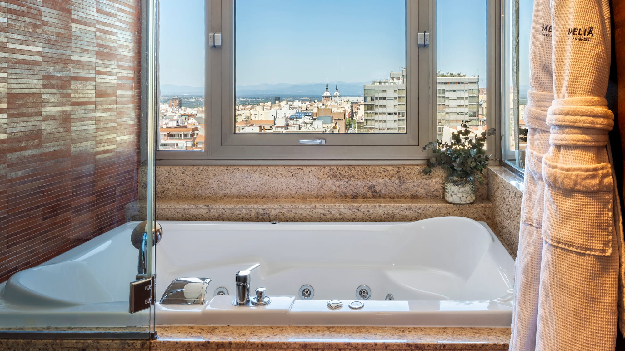 a bathtub with a window and a view of a city