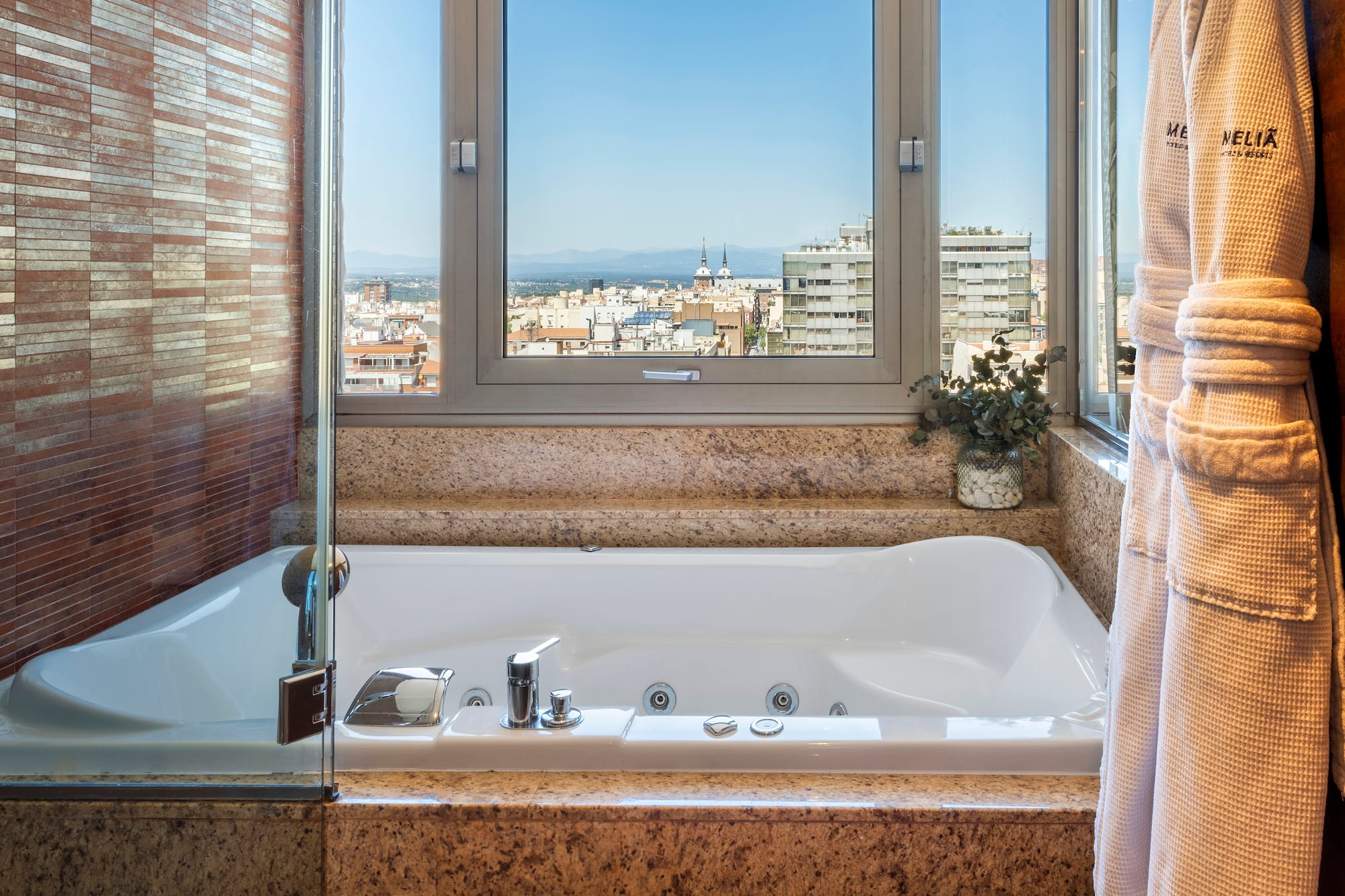 a bathtub with a window and a view of a city