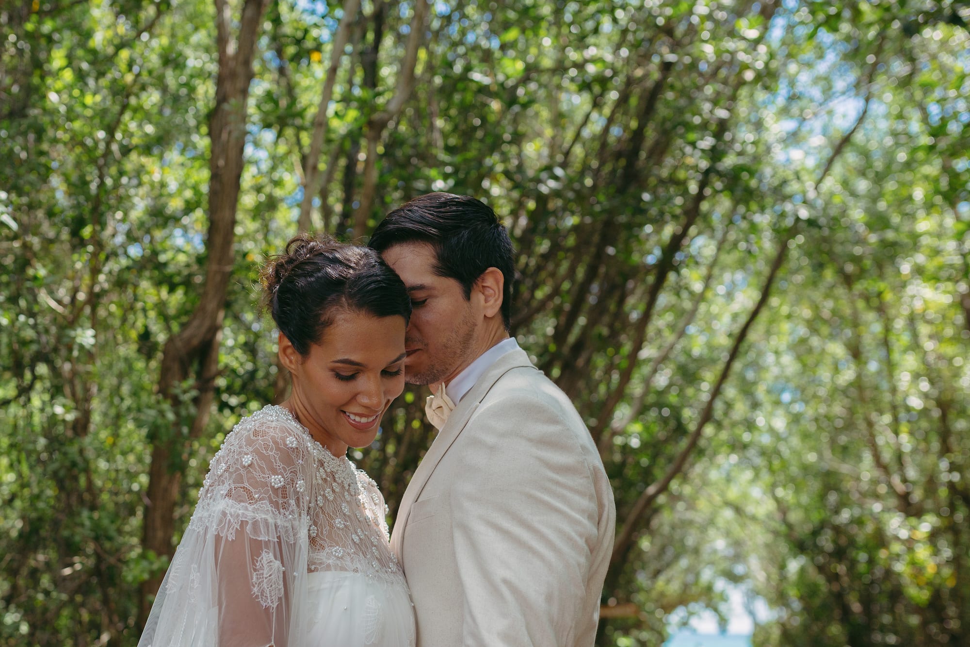 a man and woman standing in front of trees
