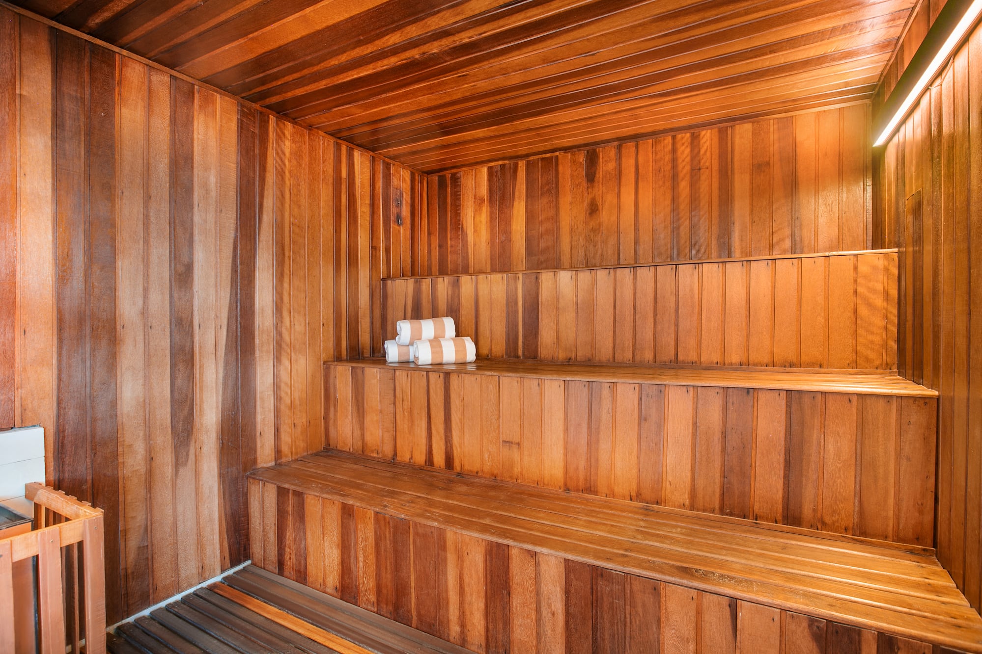 a wooden sauna with white towels on the shelves
