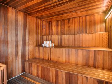 a wooden sauna with white towels on the shelves