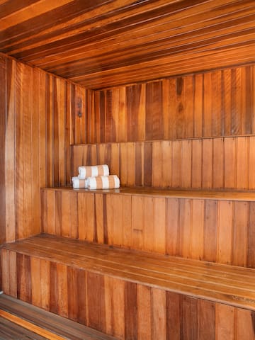 a wooden sauna with white towels on the shelves