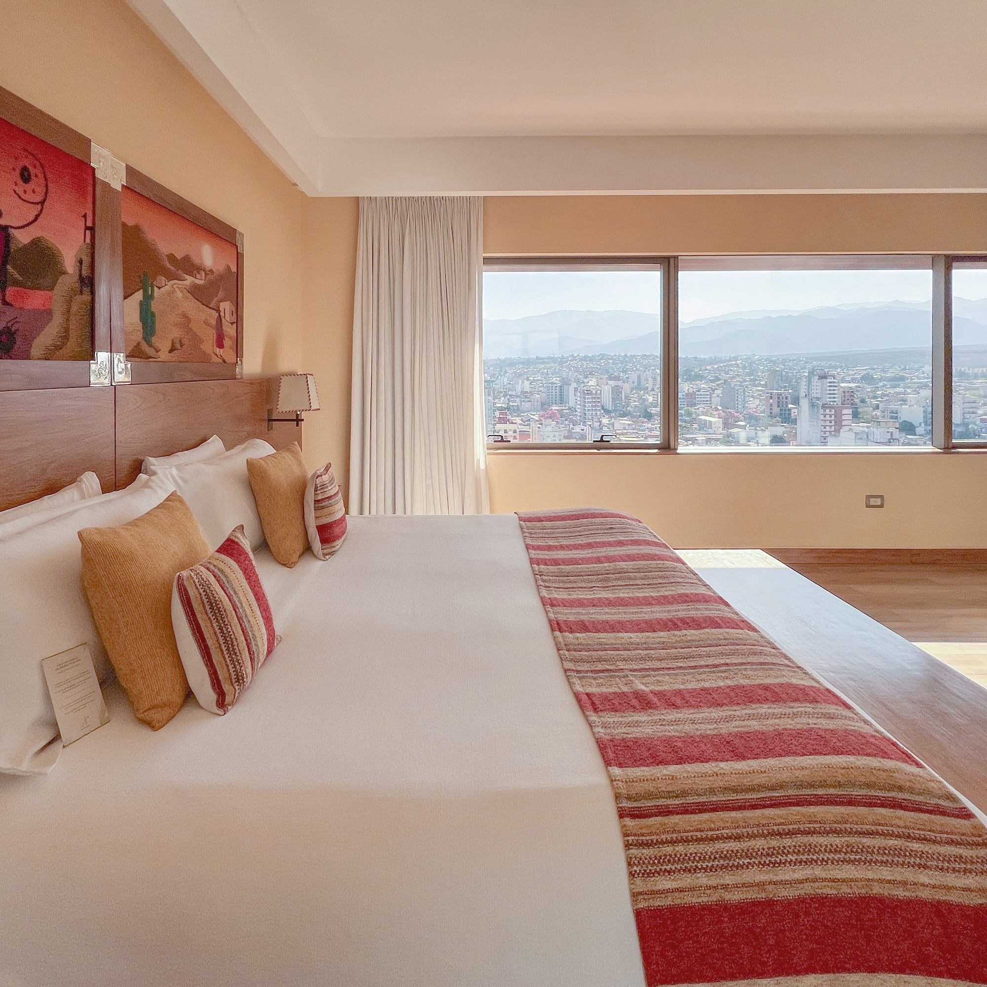 a bed with a large bed and a large window with a city view