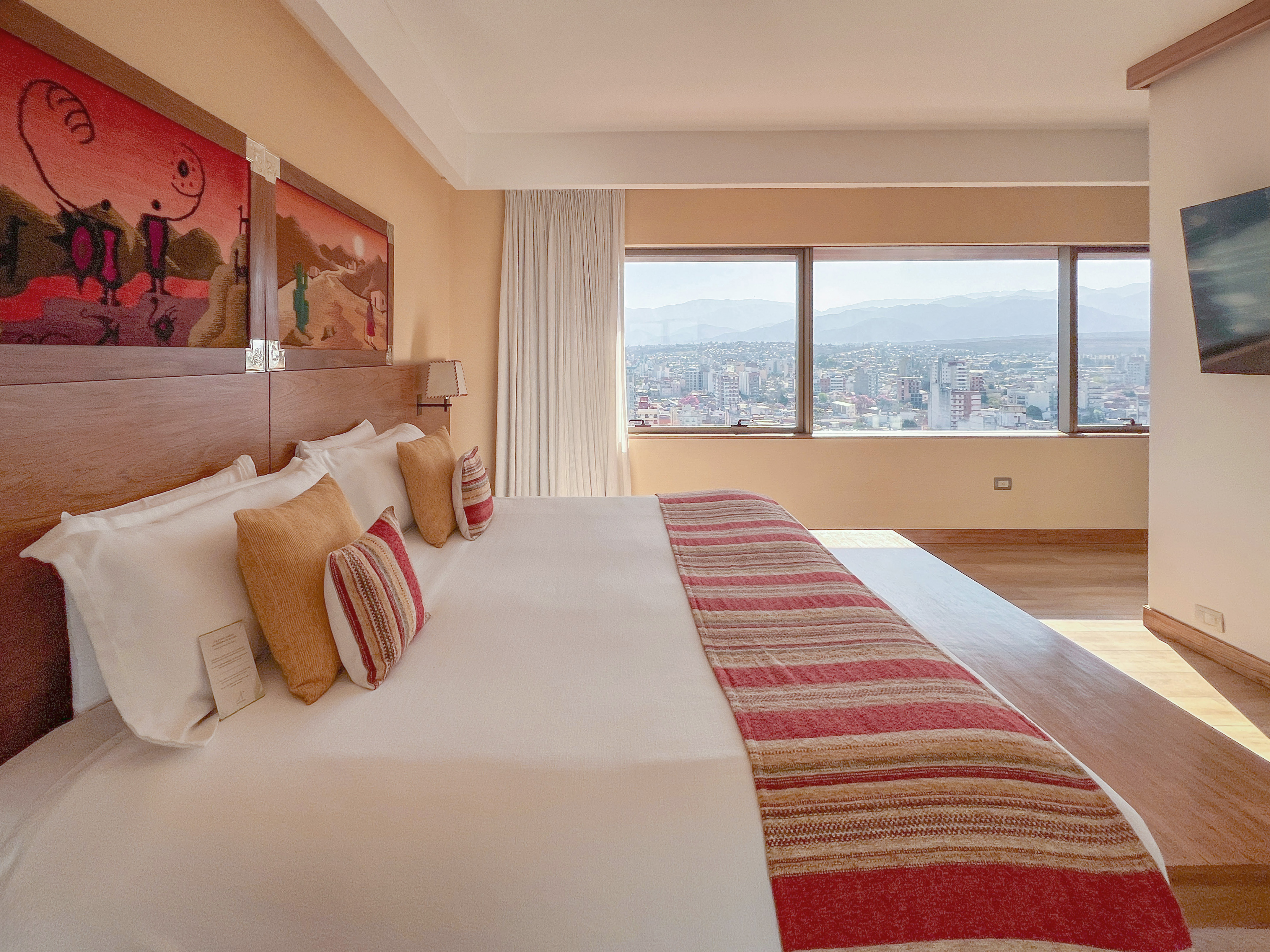 a bed with a large bed and a large window with a city view