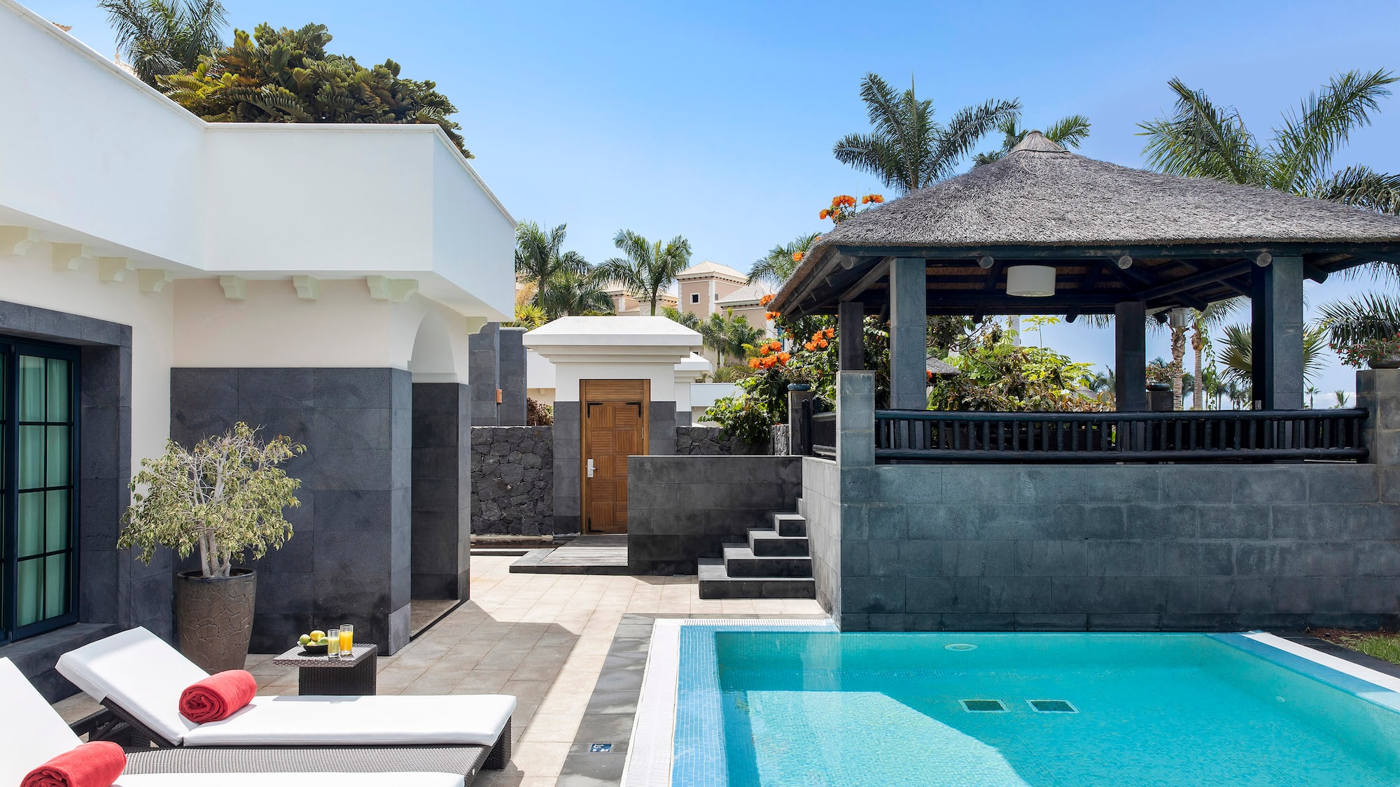 a pool with a gazebo and a wood door
