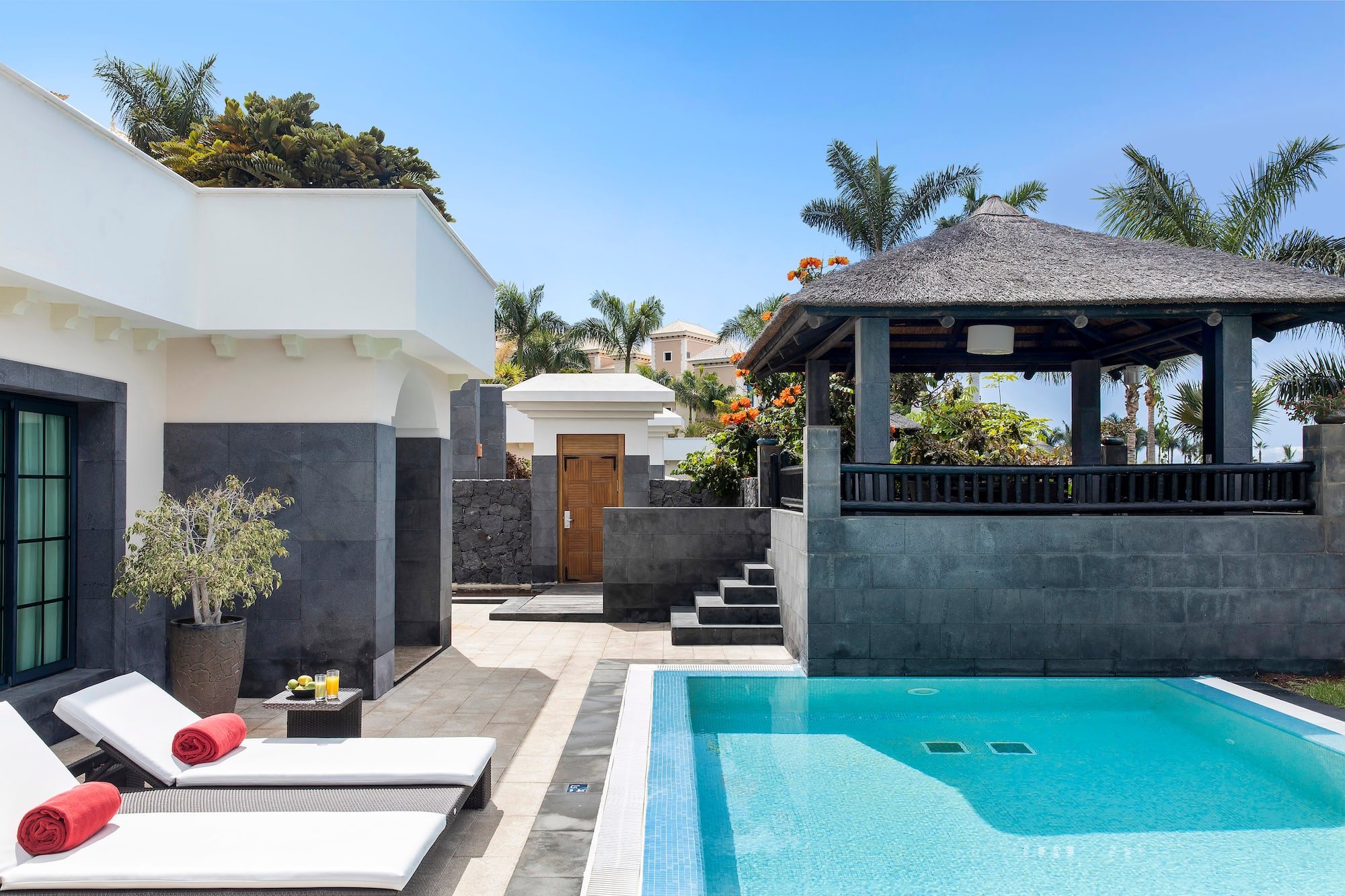 a pool with a gazebo and a wood door