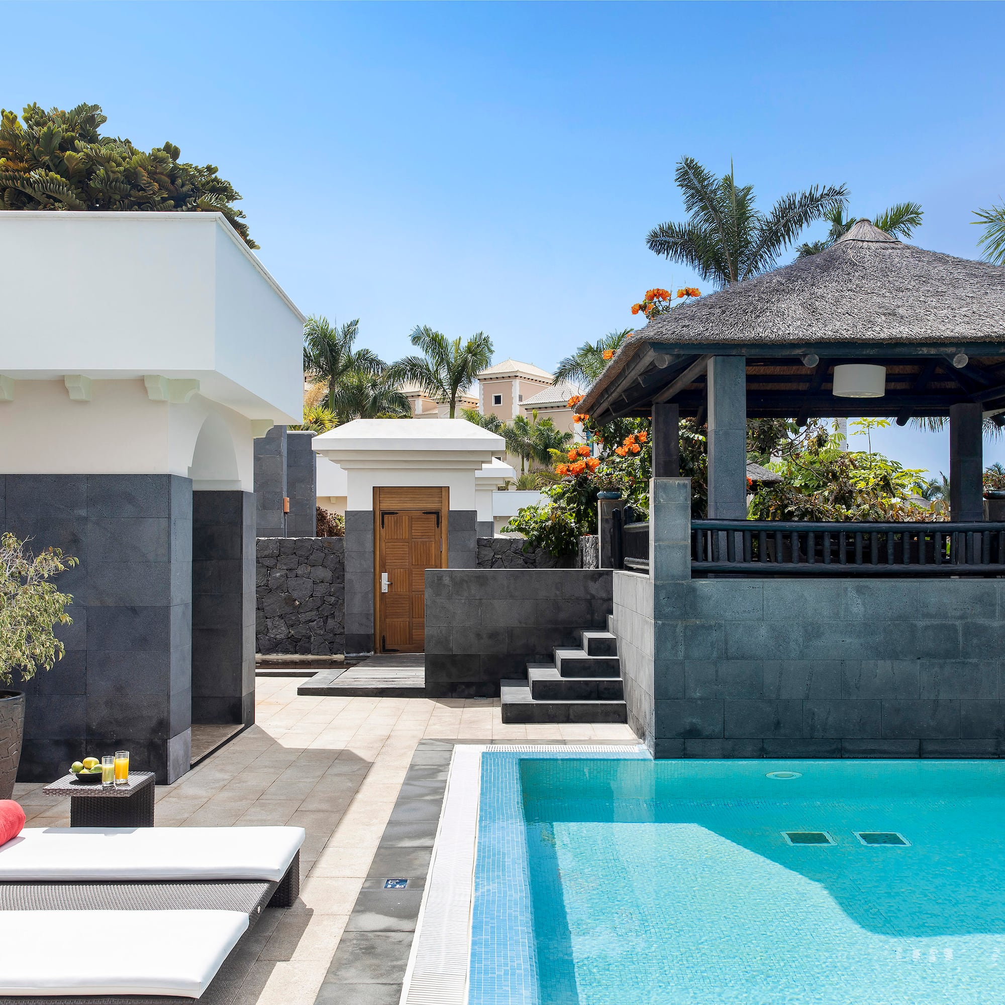 a pool with a gazebo and a wood door