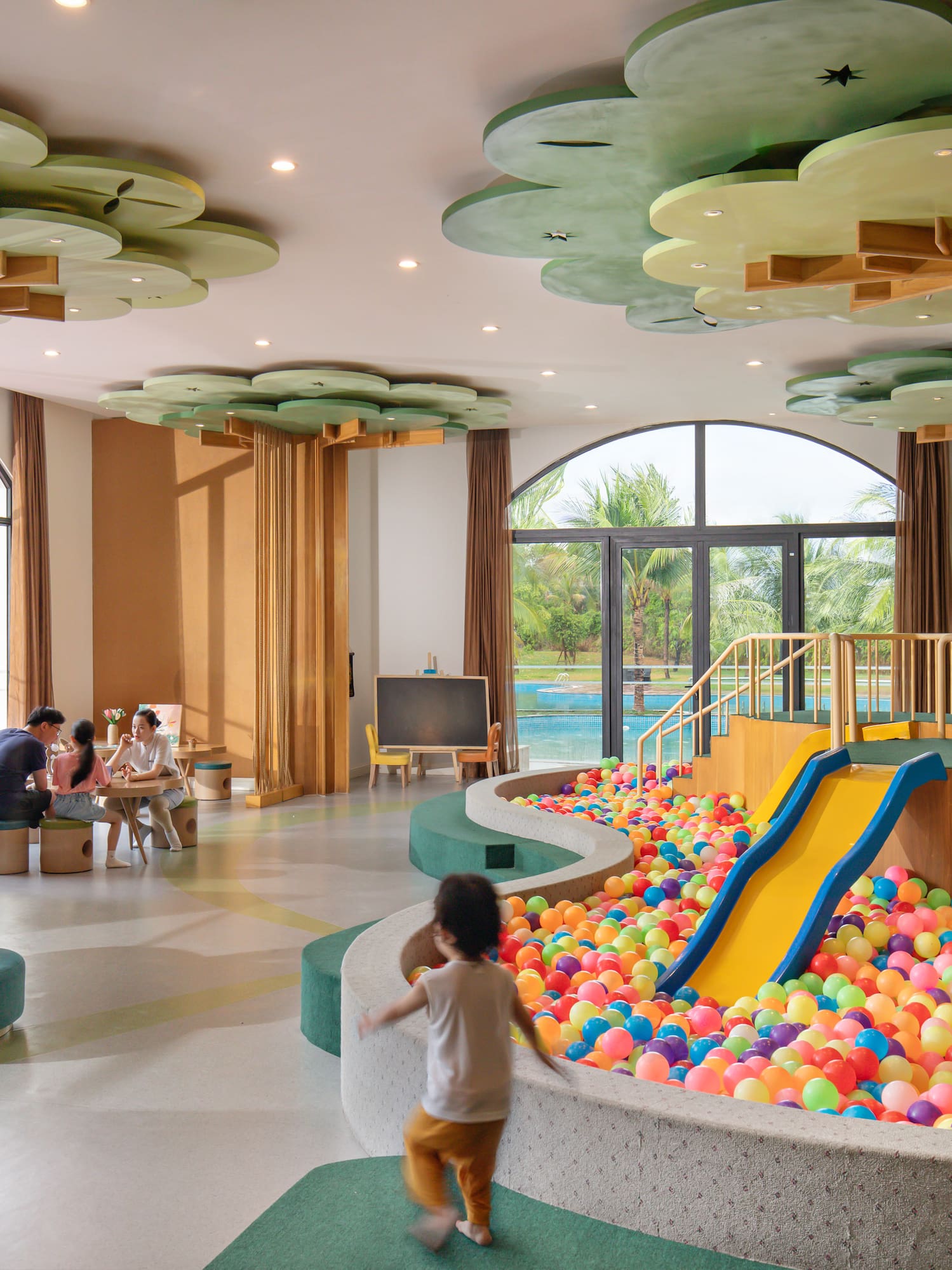 a kids playing in a play area with balls