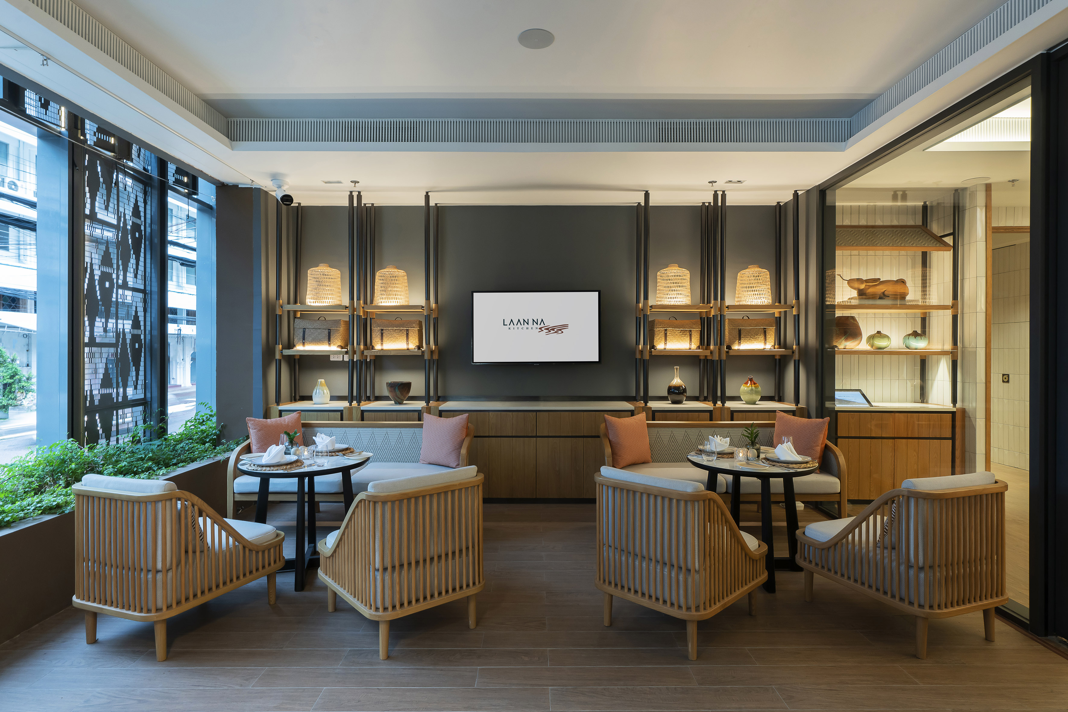 Modern Laanna Kitchen lounge, wood seating, sleek decor, bright window.