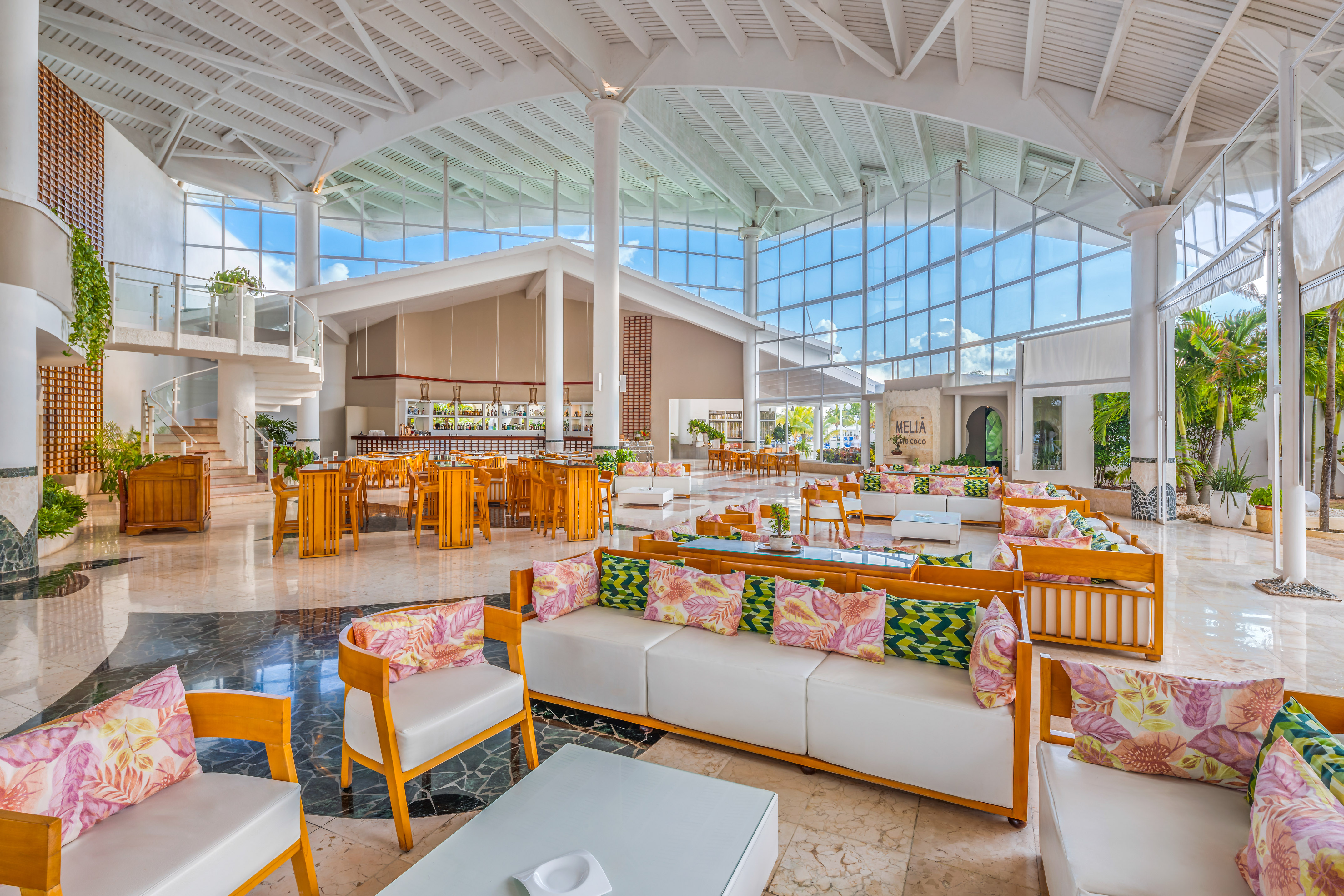 a large room with white furniture and wooden tables