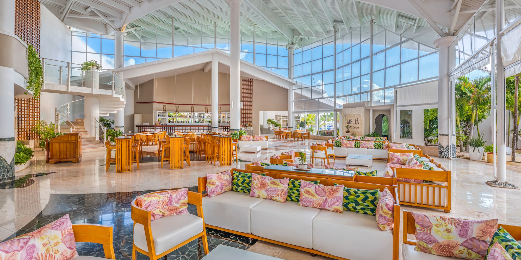 a large room with white furniture and wooden tables