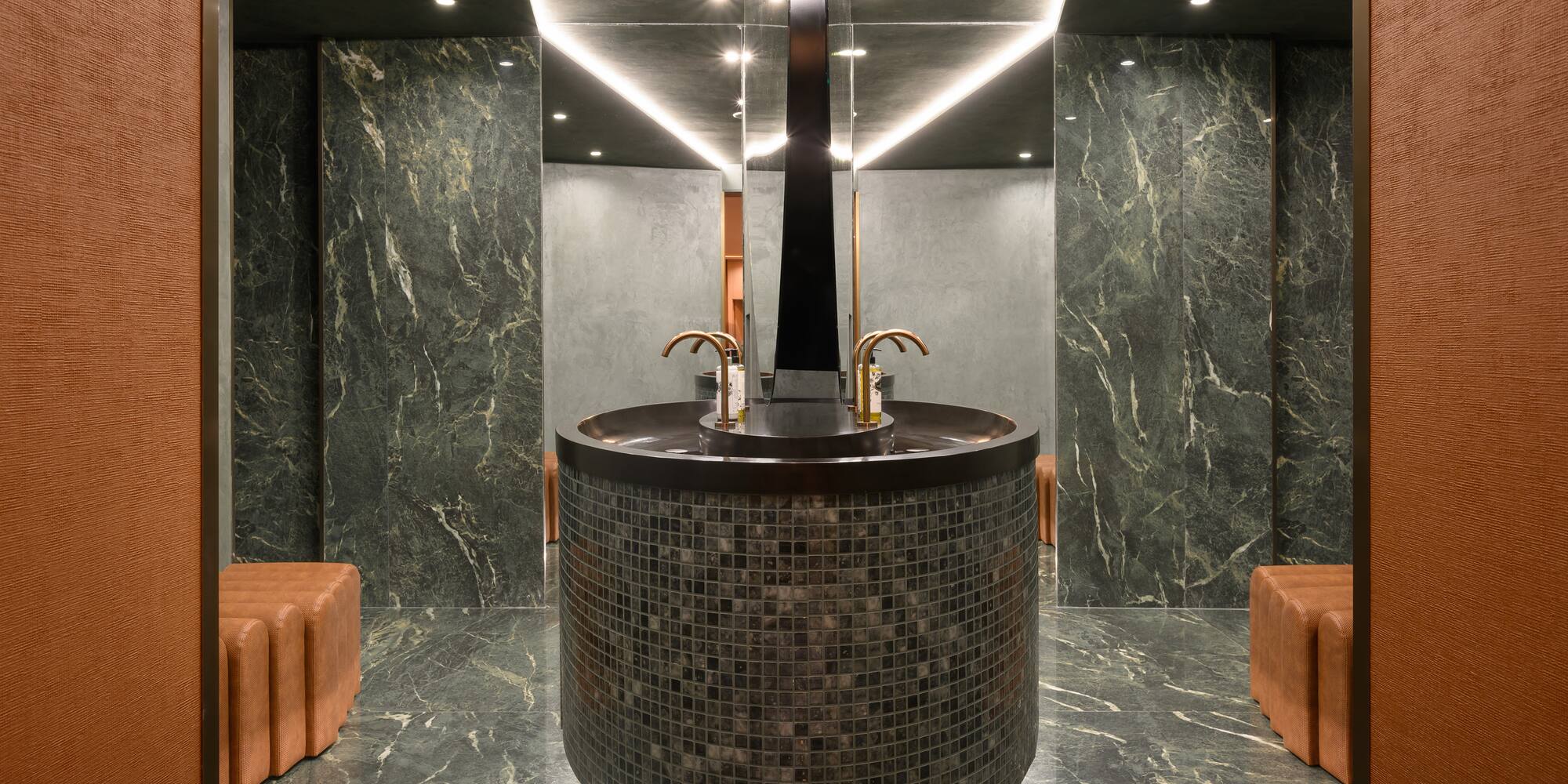 a round sink in a room with brown chairs