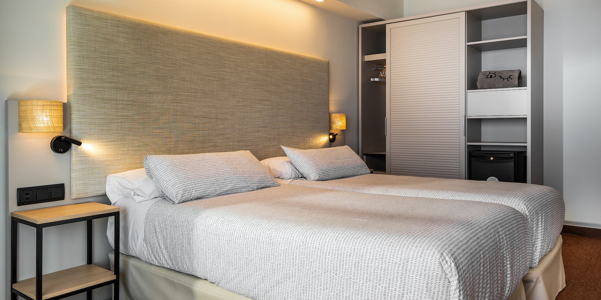 a bed with a headboard and a lamp