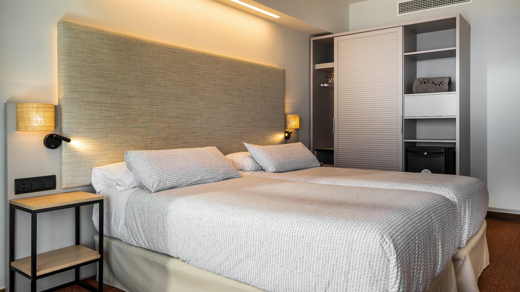 a bed with a headboard and a lamp