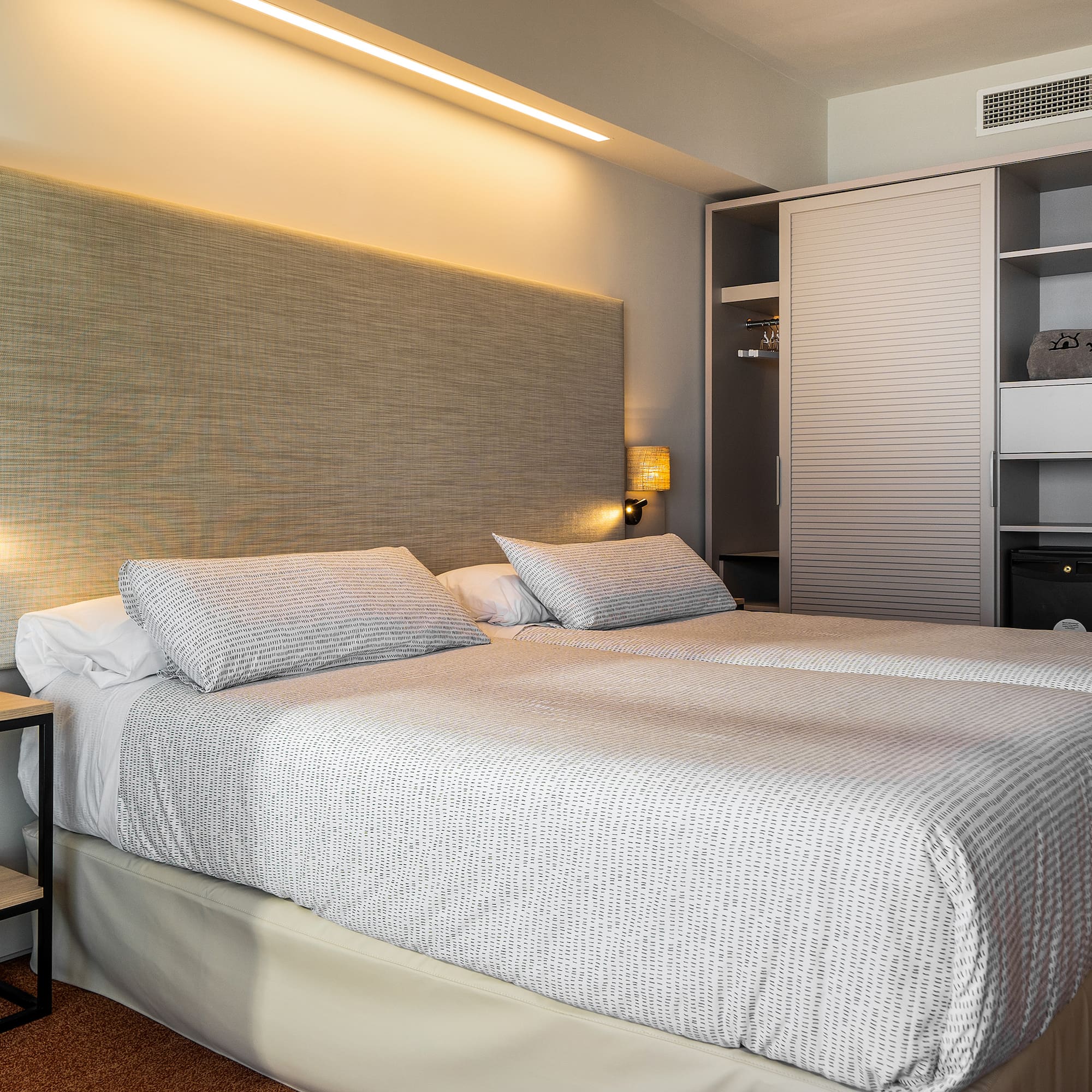 a bed with a headboard and a lamp