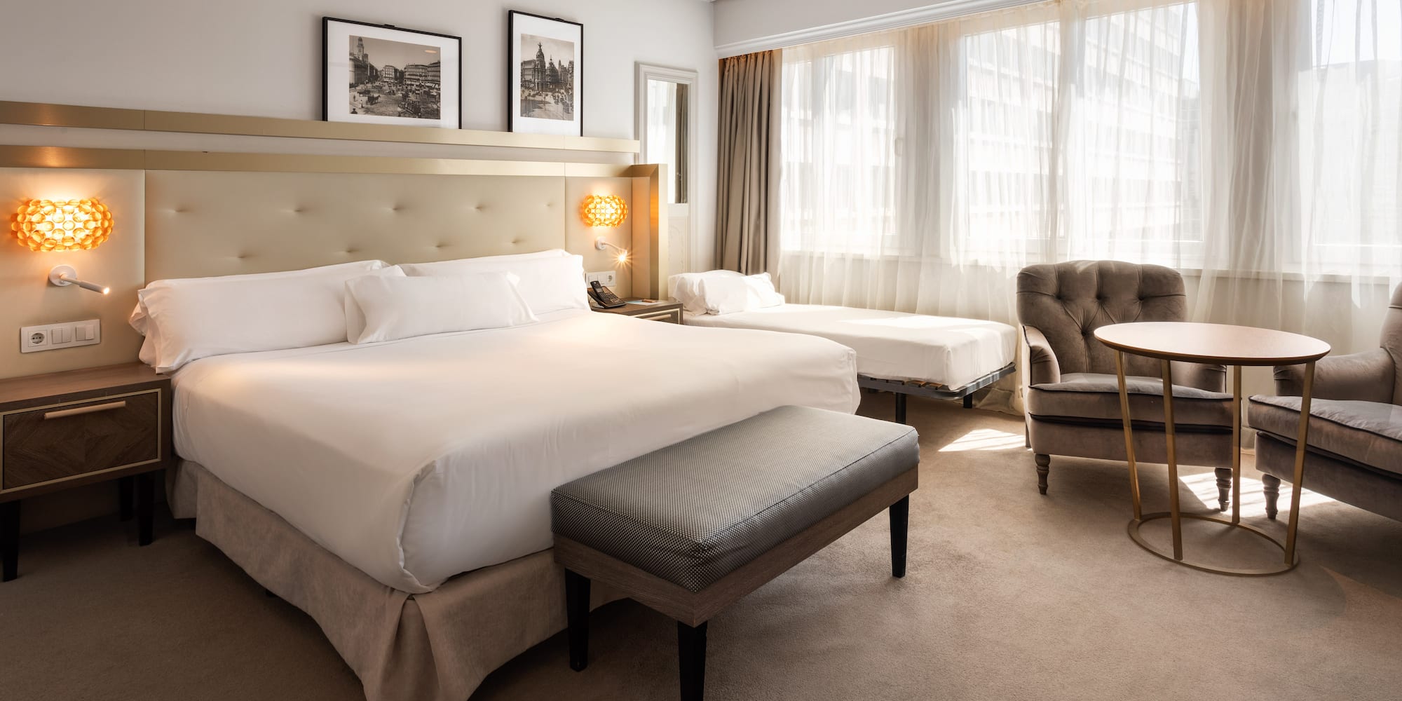 a room with a bed and chairs