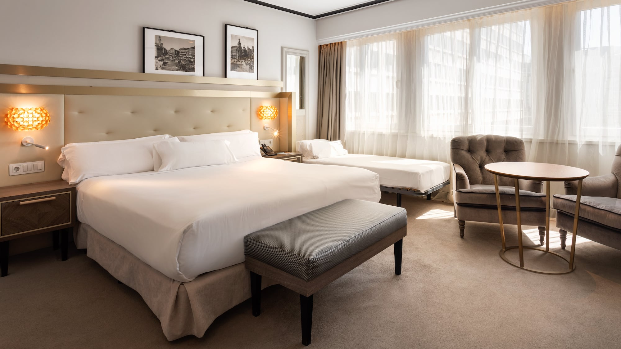 a room with a bed and chairs