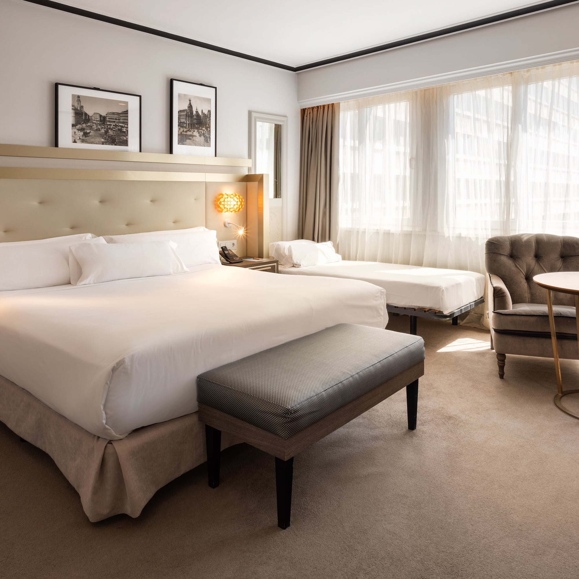 a room with a bed and chairs