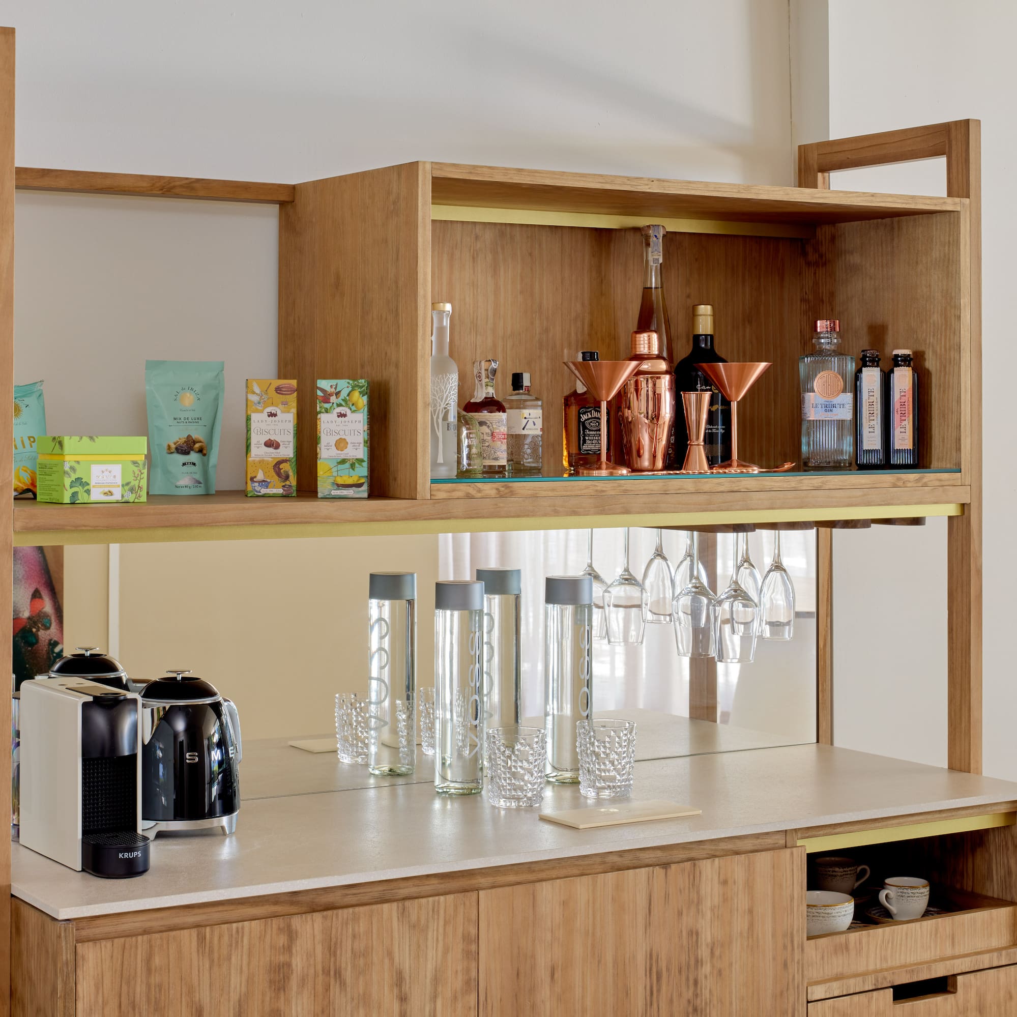 Stylish wooden minibar featuring coffee machine, liquor, snacks, and barware.