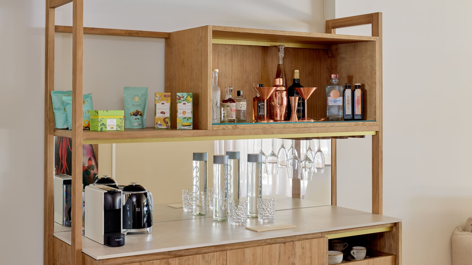 Stylish wooden minibar featuring coffee machine, liquor, snacks, and barware.