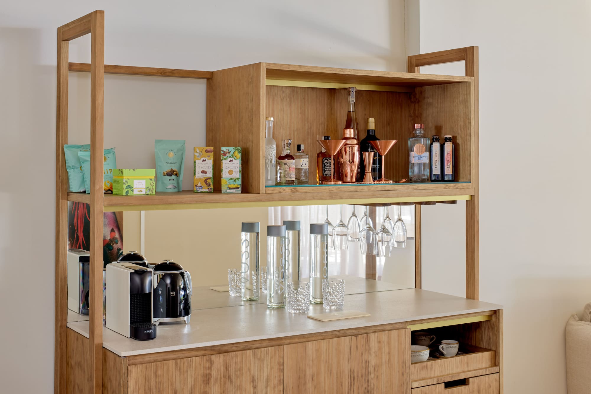 Stylish wooden minibar featuring coffee machine, liquor, snacks, and barware.