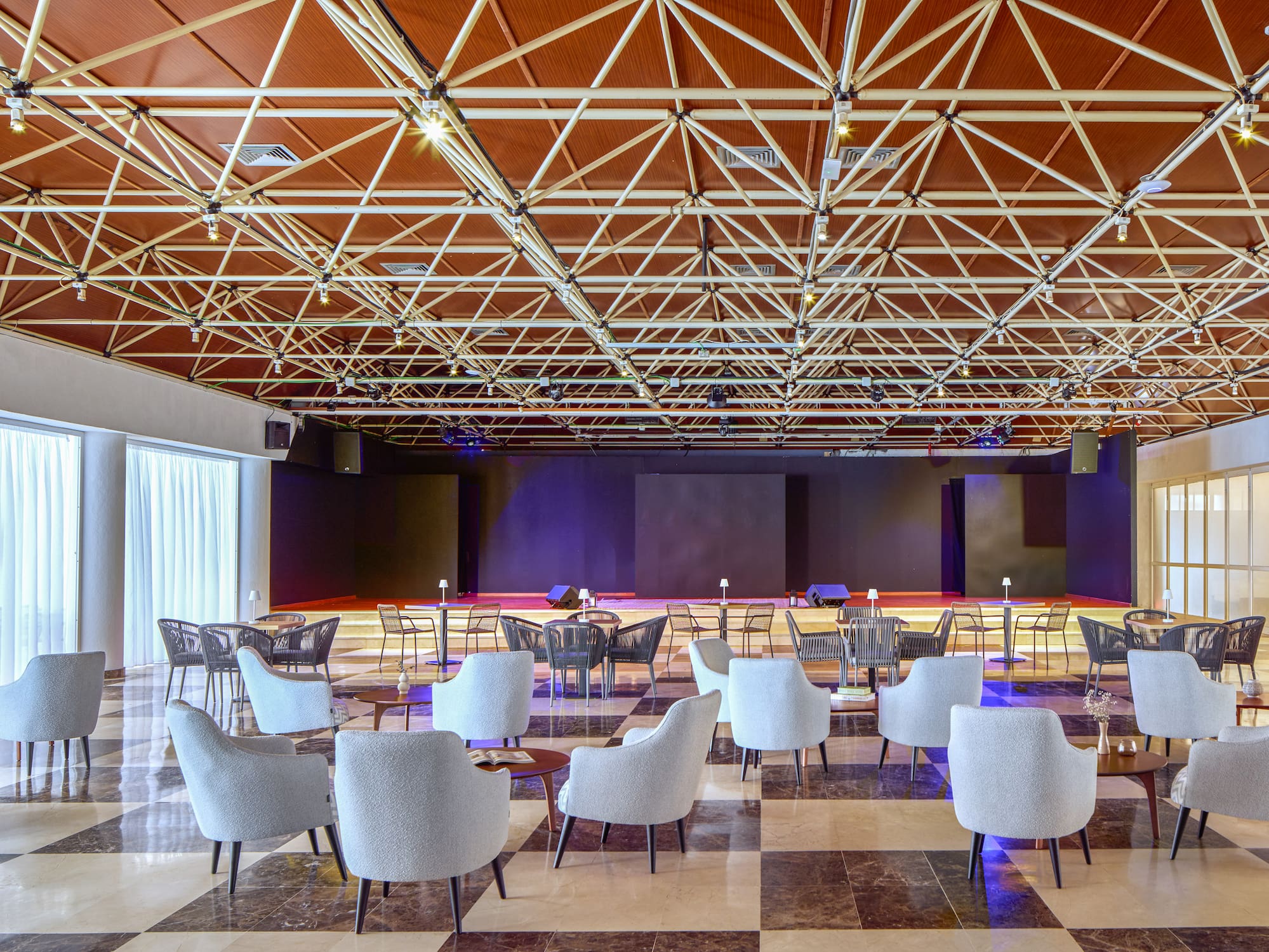 a room with a large black and white floor and chairs