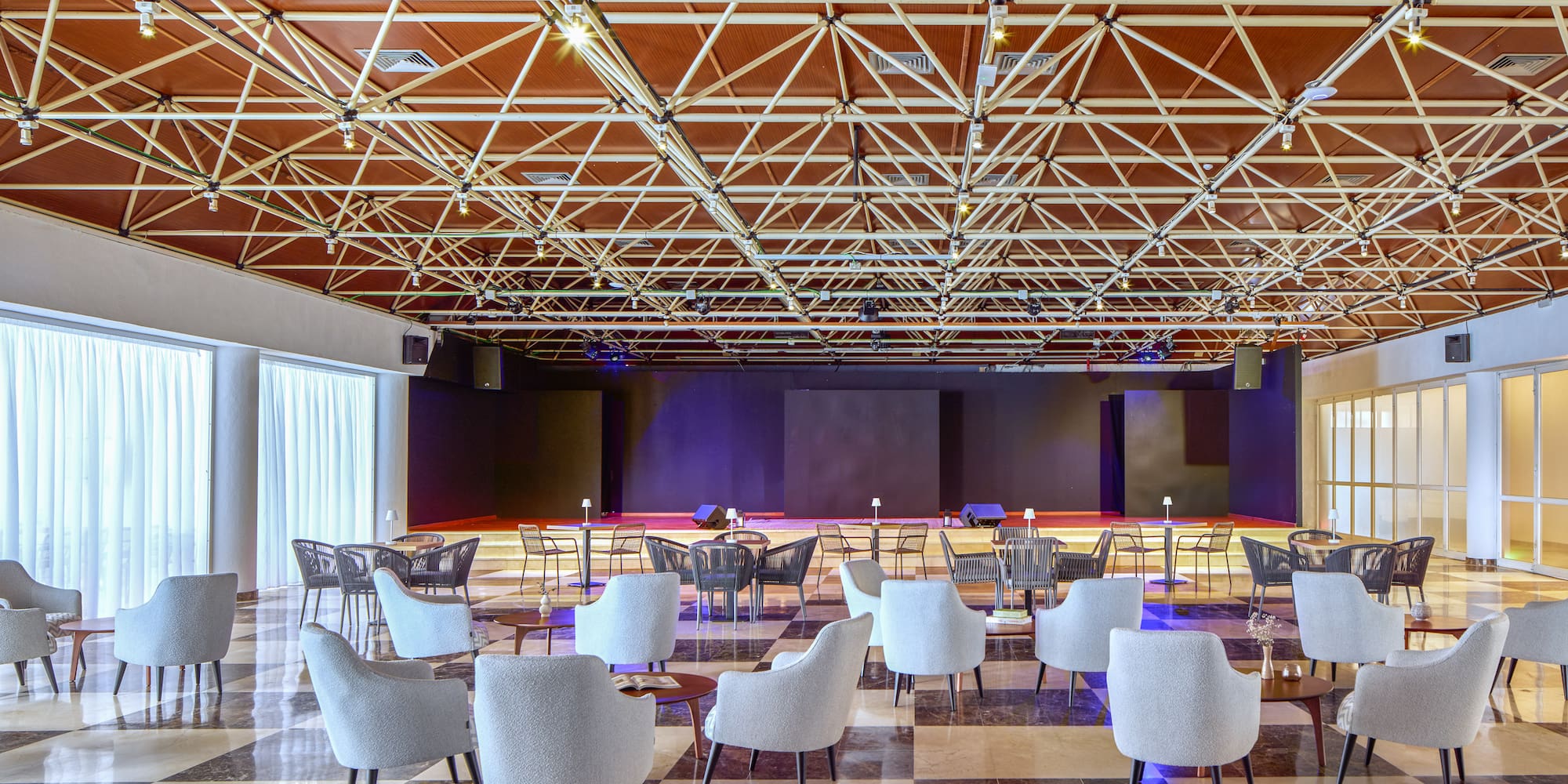 a room with a large black and white floor and chairs