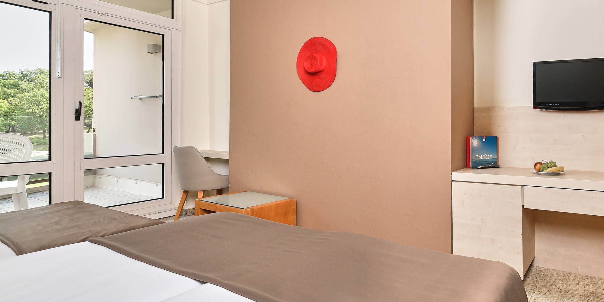 a room with a bed and a red hat on the wall