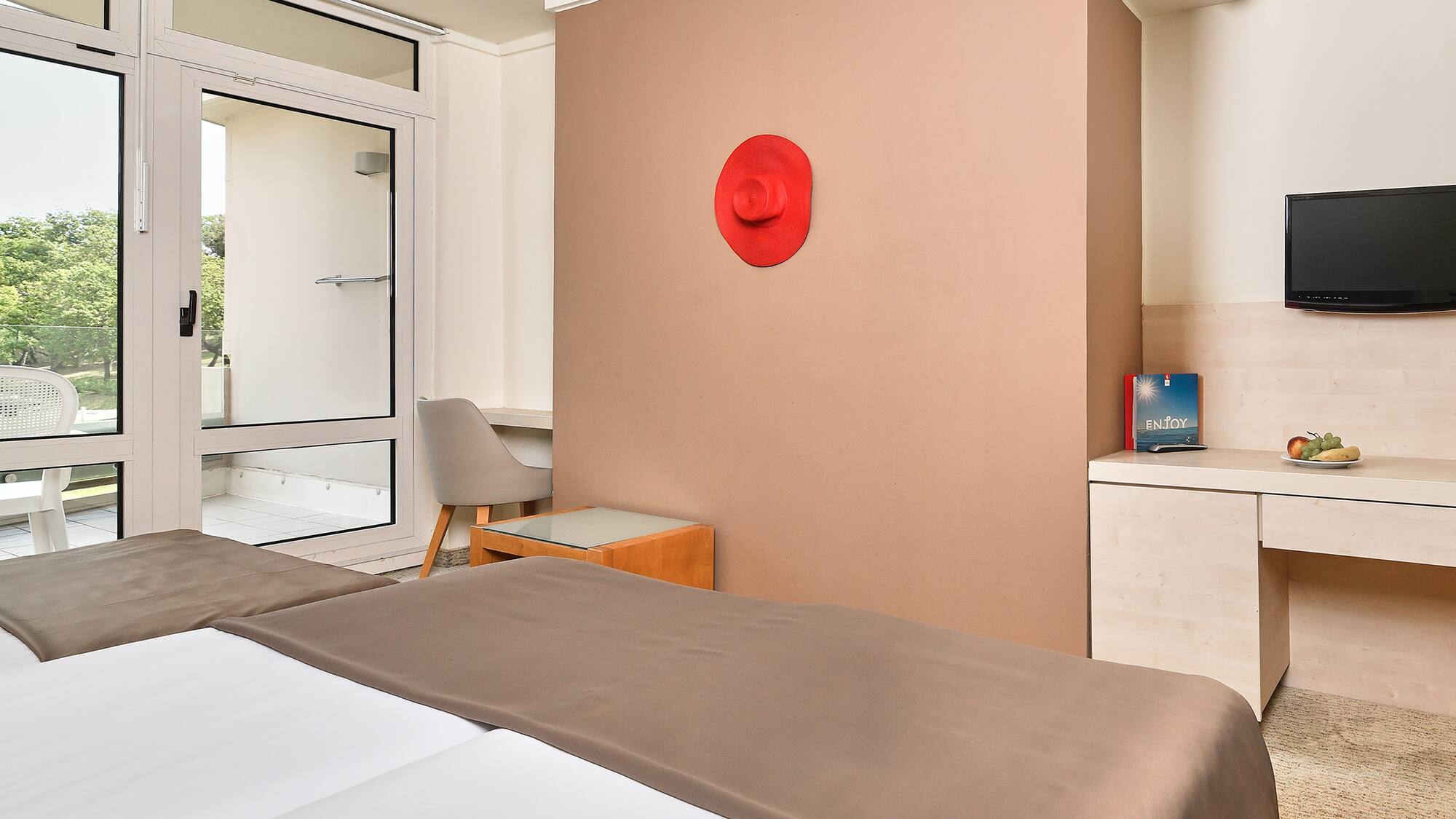 a room with a bed and a red hat on the wall