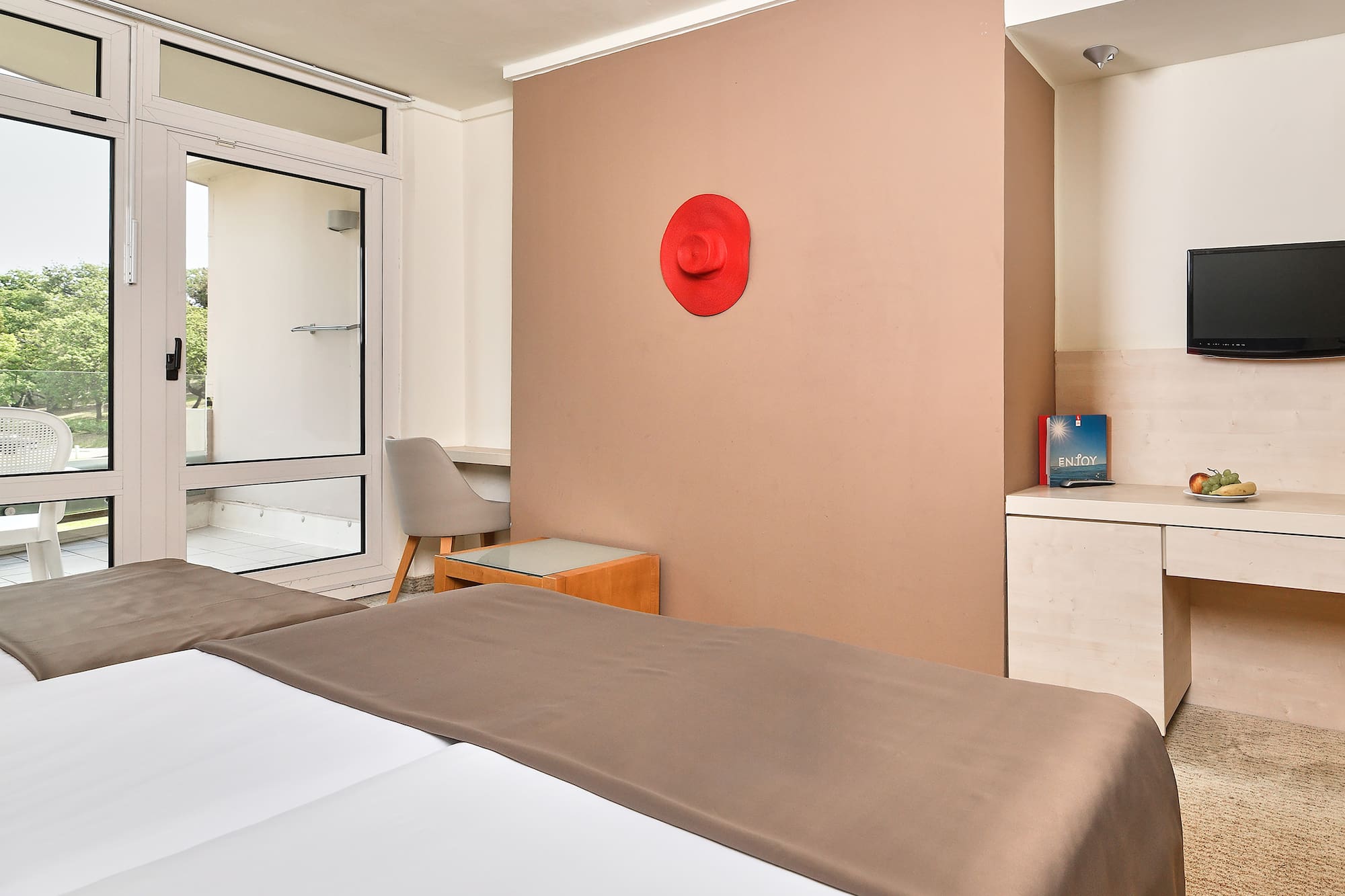 a room with a bed and a red hat on the wall