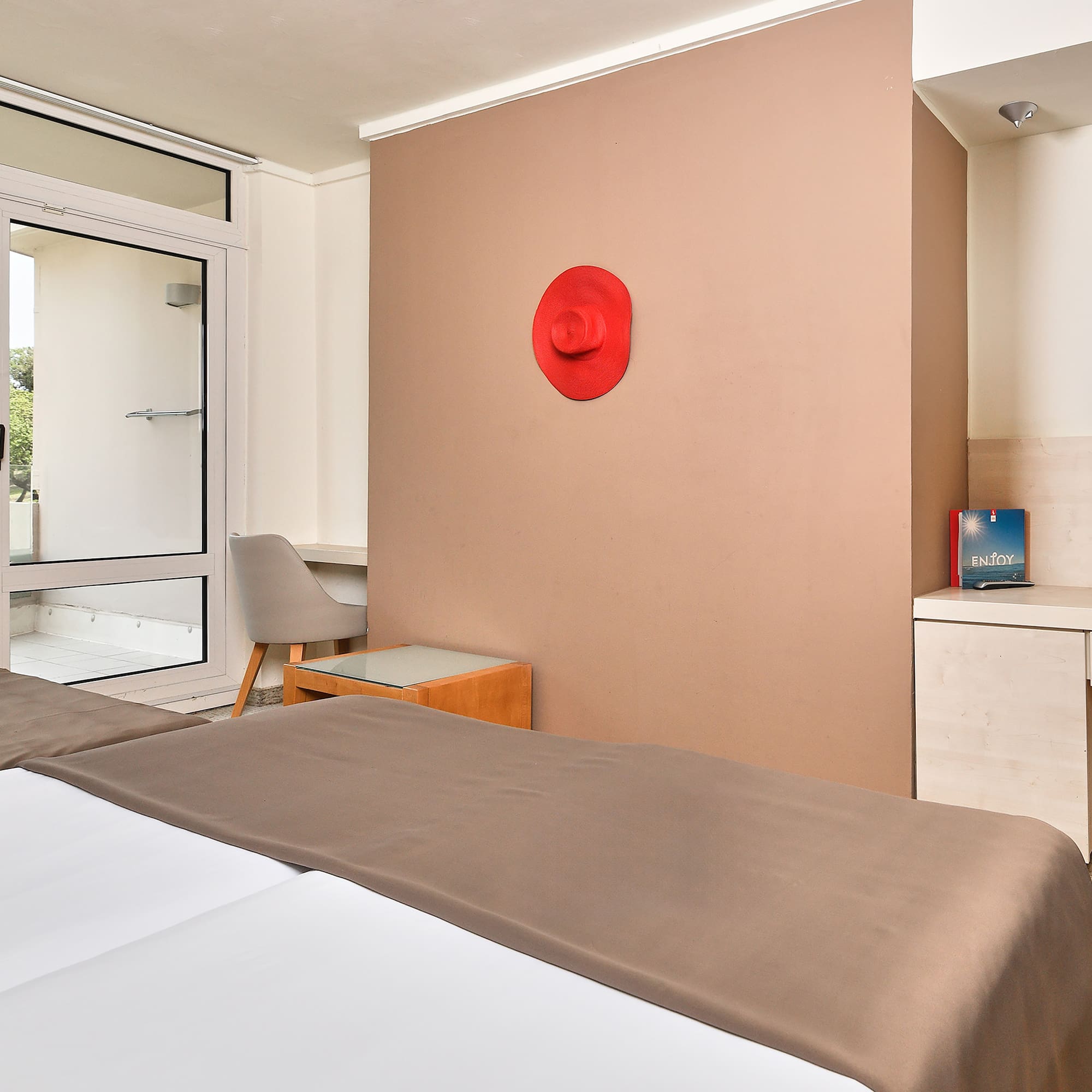 a room with a bed and a red hat on the wall