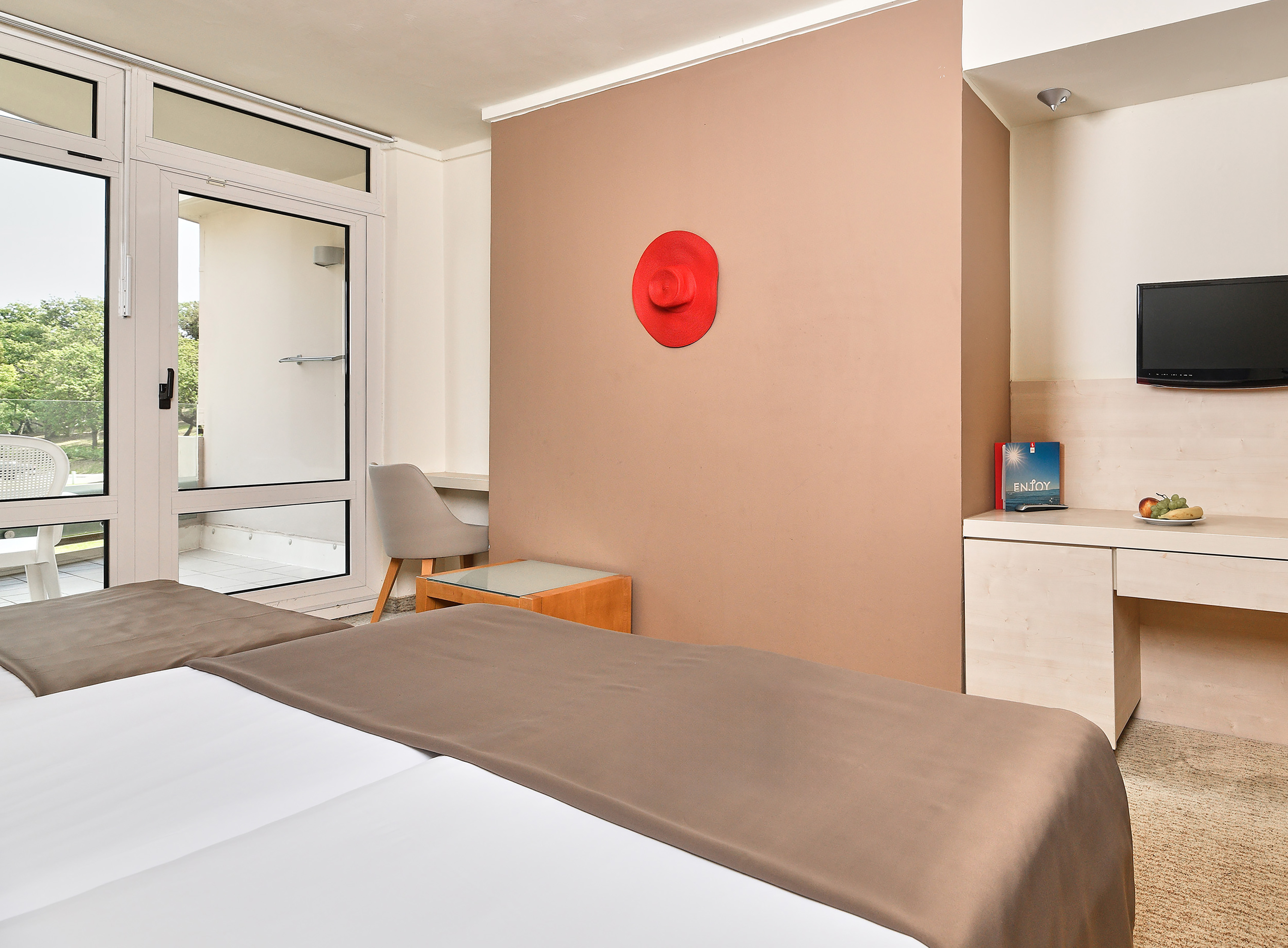 a room with a bed and a red hat on the wall