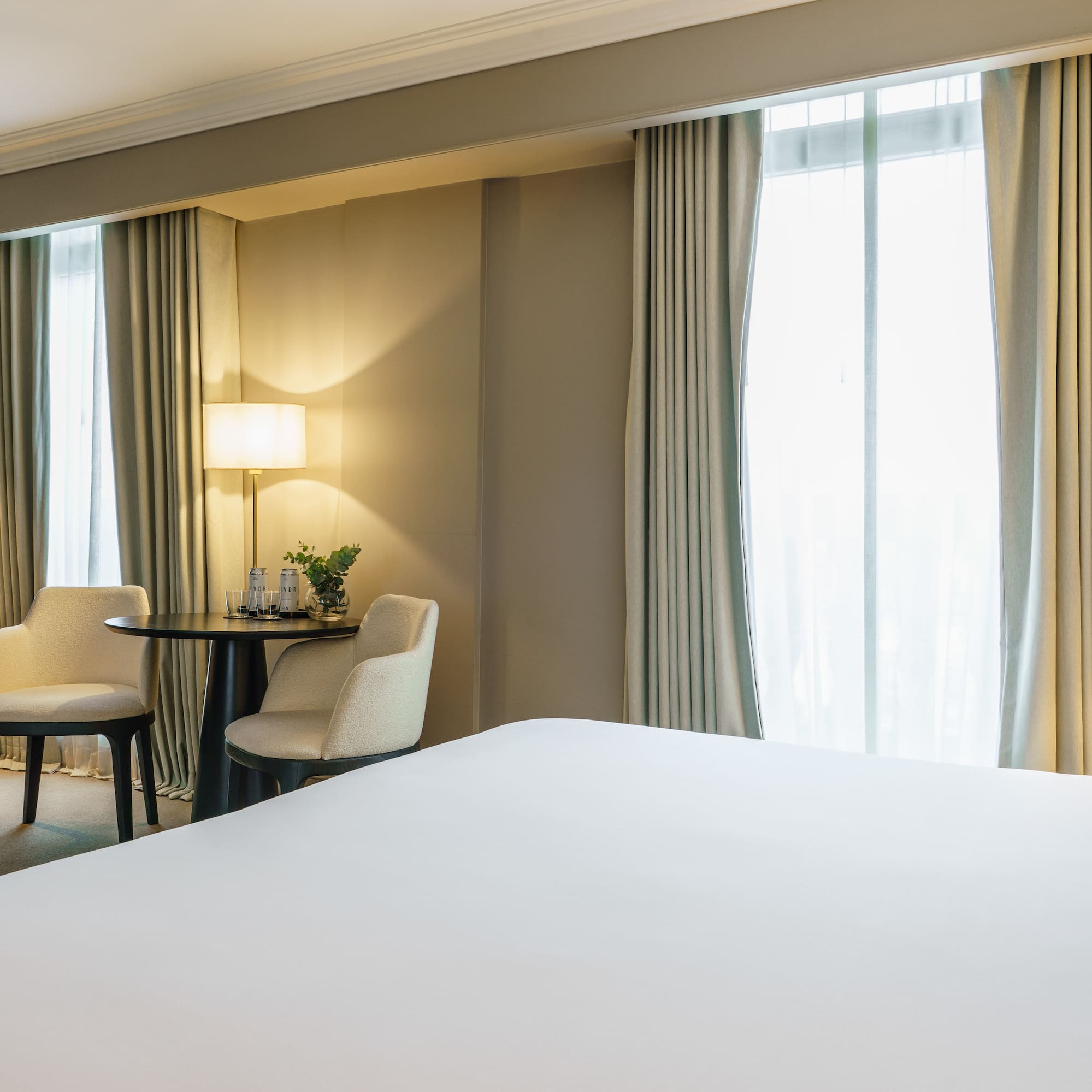 a room with a bed and chairs