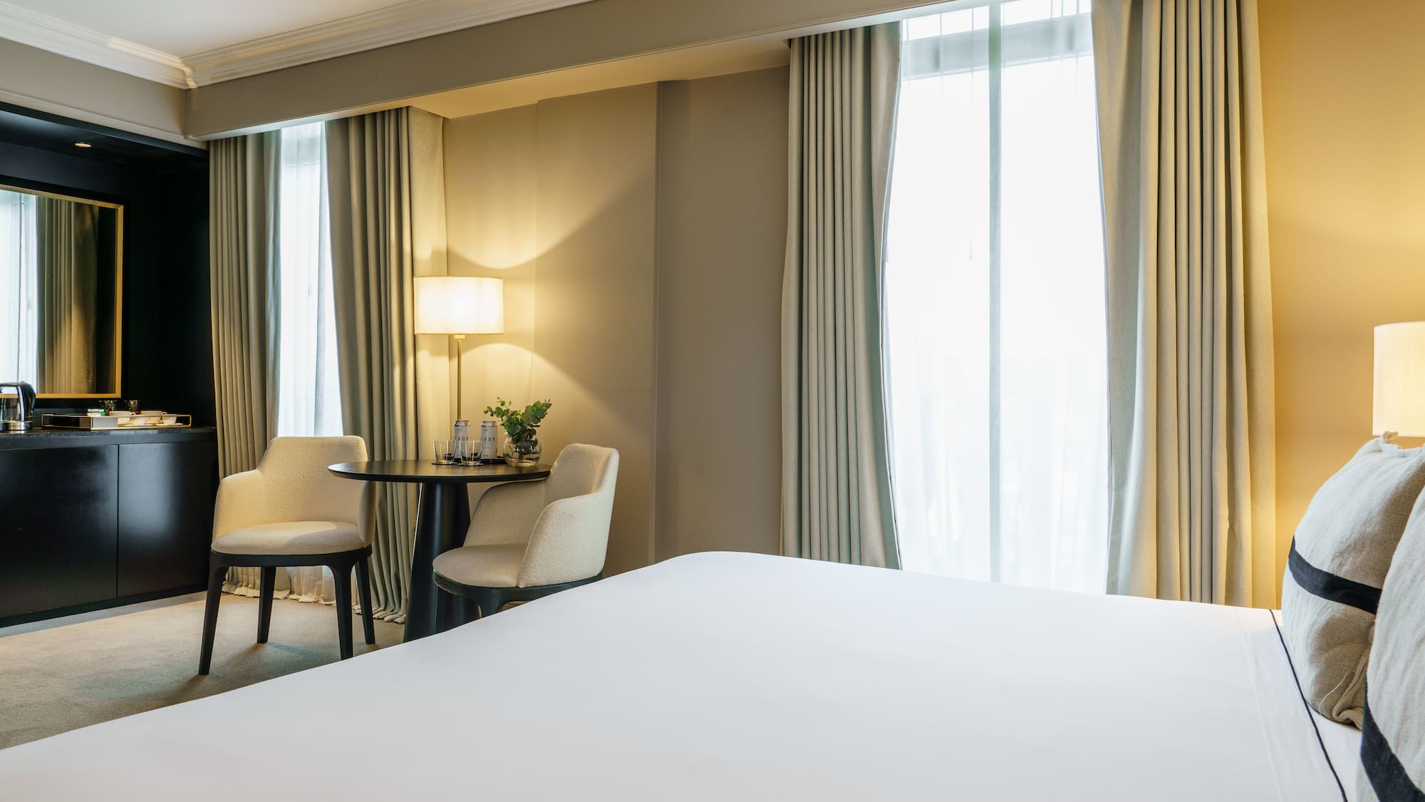 a room with a bed and chairs