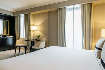 a room with a bed and chairs