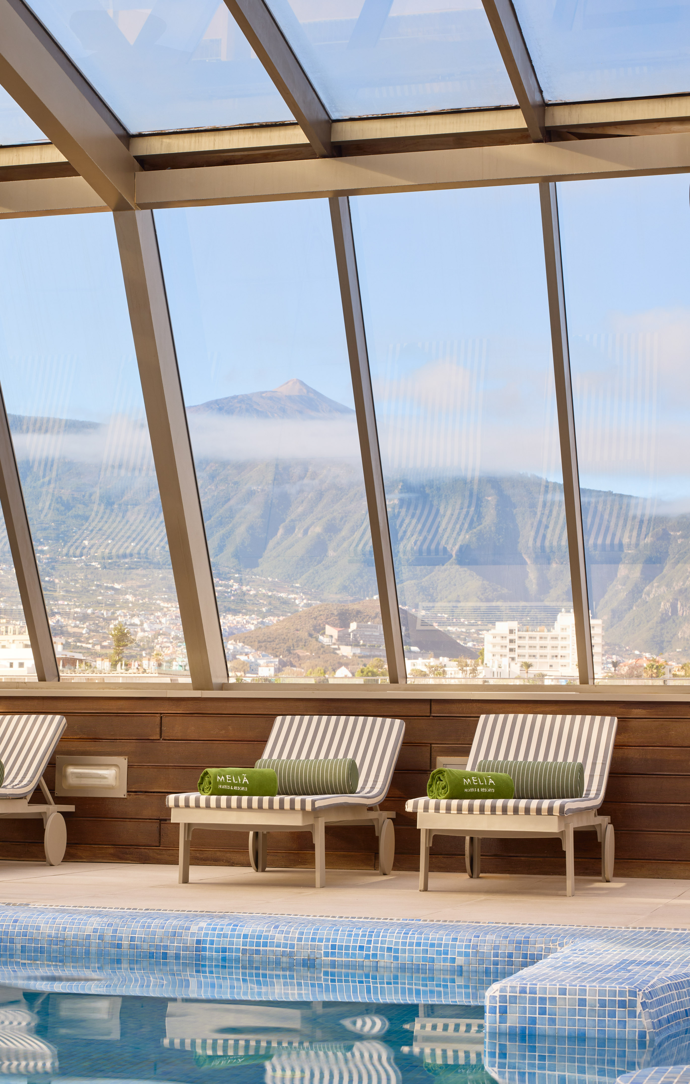 Indoor hotel pool with loungers, panoramic mountain view, Meliã resort, Tenerife.